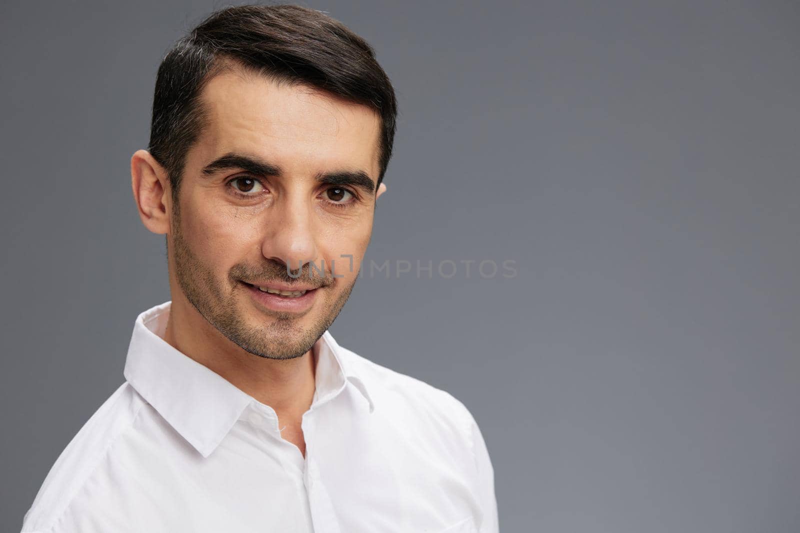 handsome man in a white shirt a pensive look isolated background. High quality photo