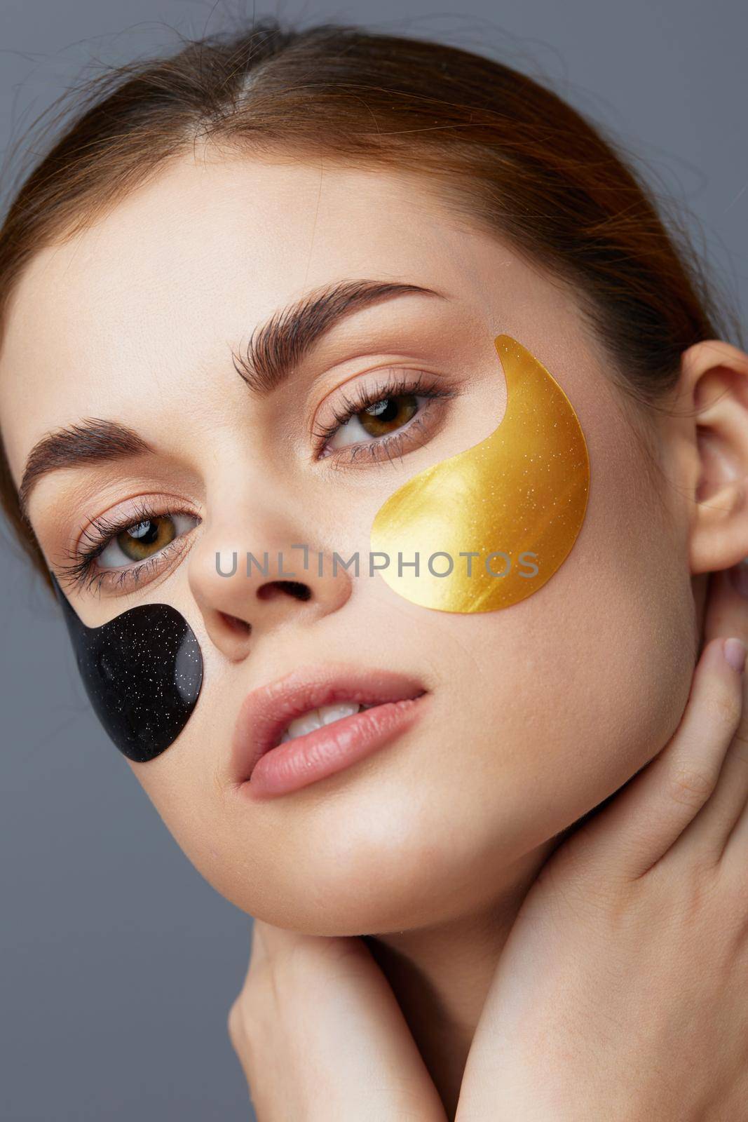 woman black and gold patches on the face gray background. High quality photo