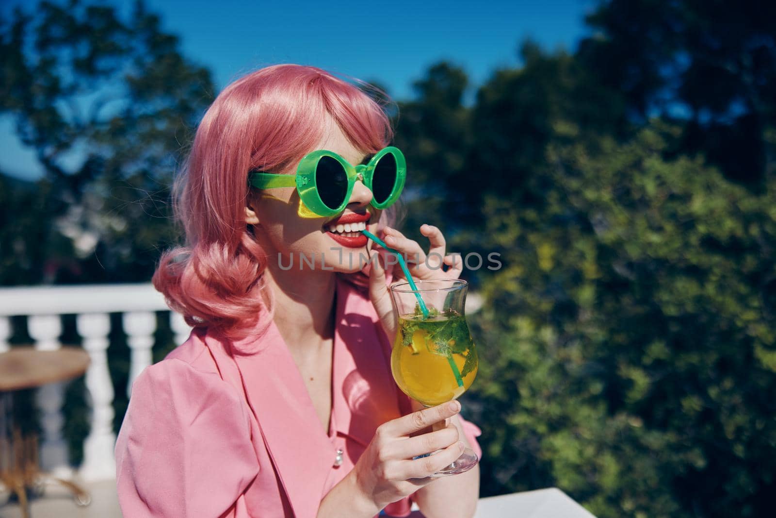 Young female in pink dress outdoors with cocktail Relaxation concept by SHOTPRIME