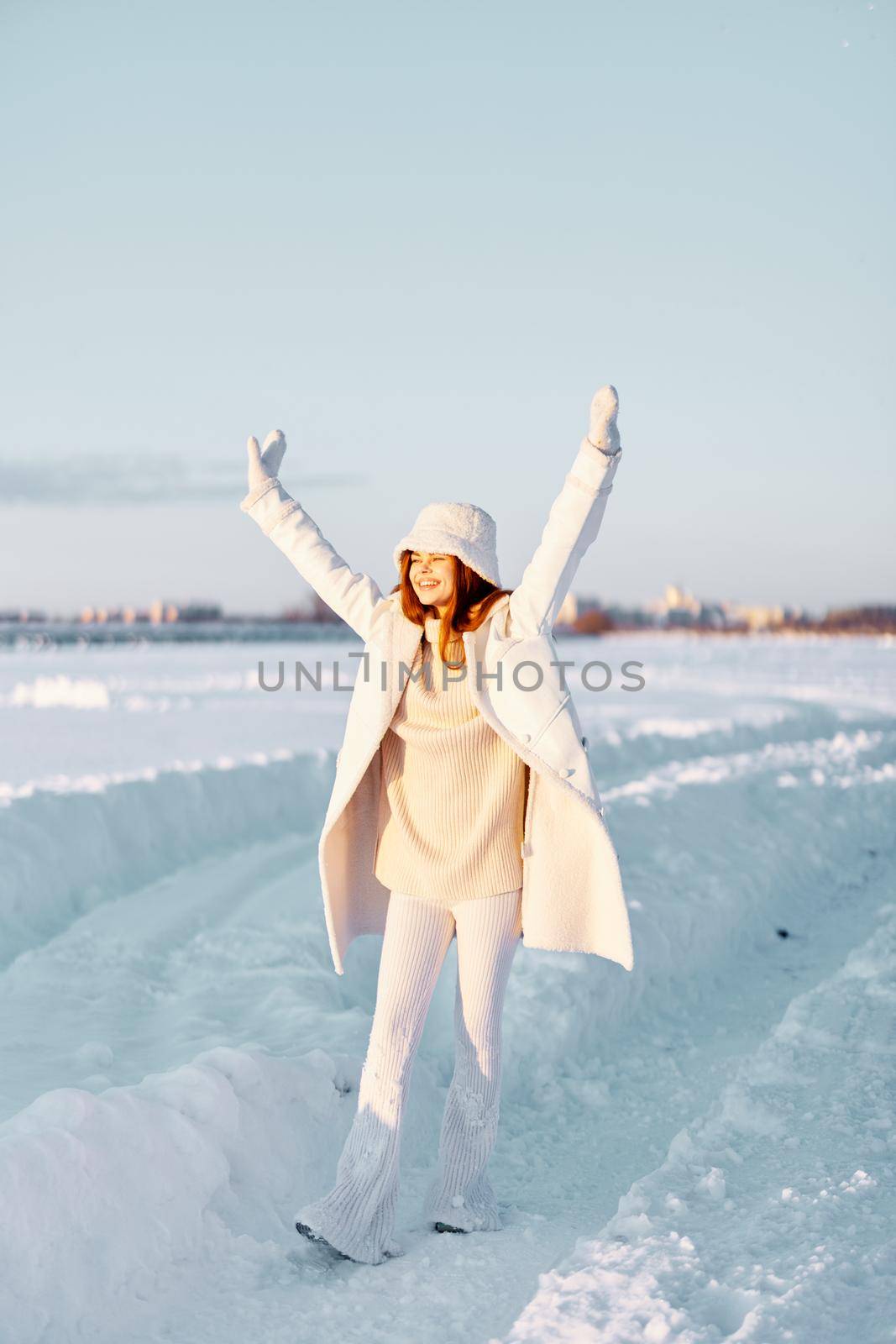 beautiful woman in a white coat in a hat winter landscape walk Fresh air. High quality photo
