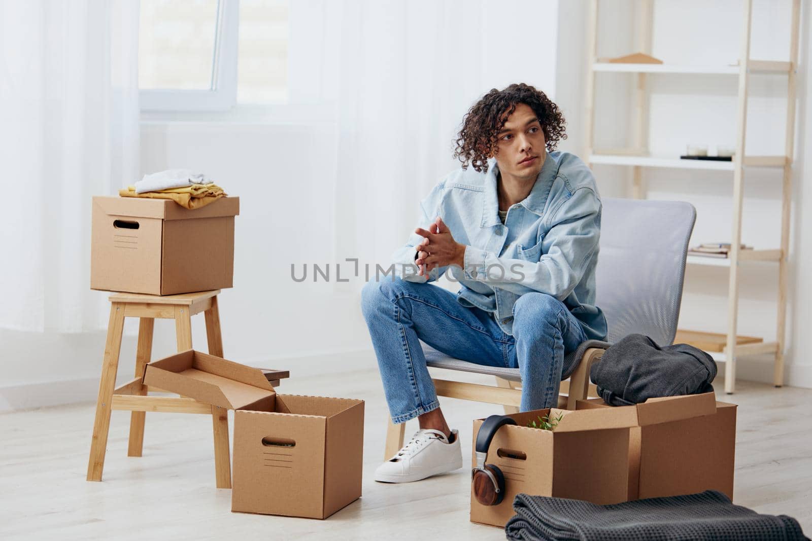 A young man unpacking things from boxes in the room interior. High quality photo
