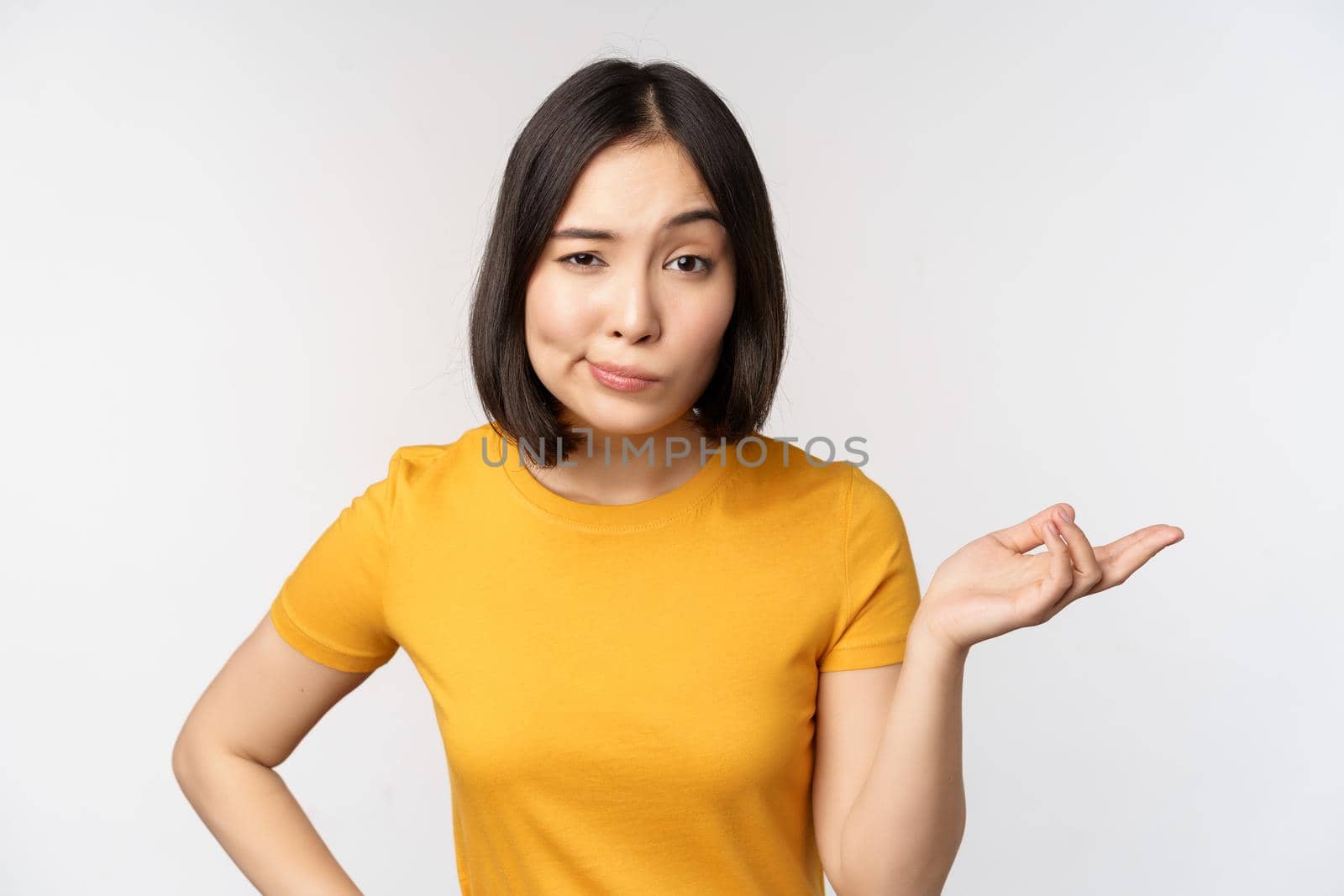 So what. Unbothered asian woman shrugging, looking clueless, standing against white background. Copy space