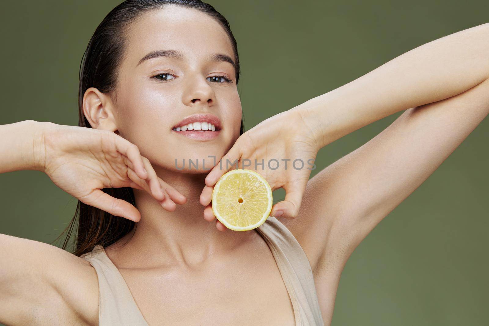 beautiful woman eating lemon in hands smile vitamins diet green background. High quality photo