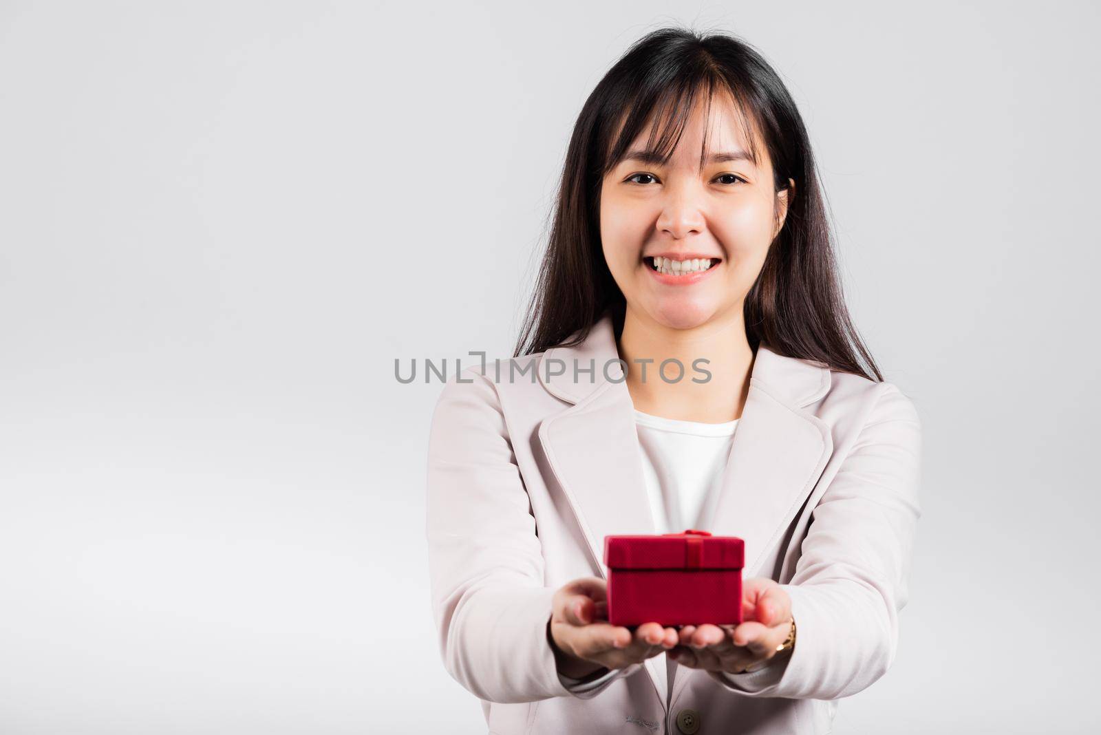 Smiling woman confidence holding red gift box on hands palm isolated white background by Sorapop