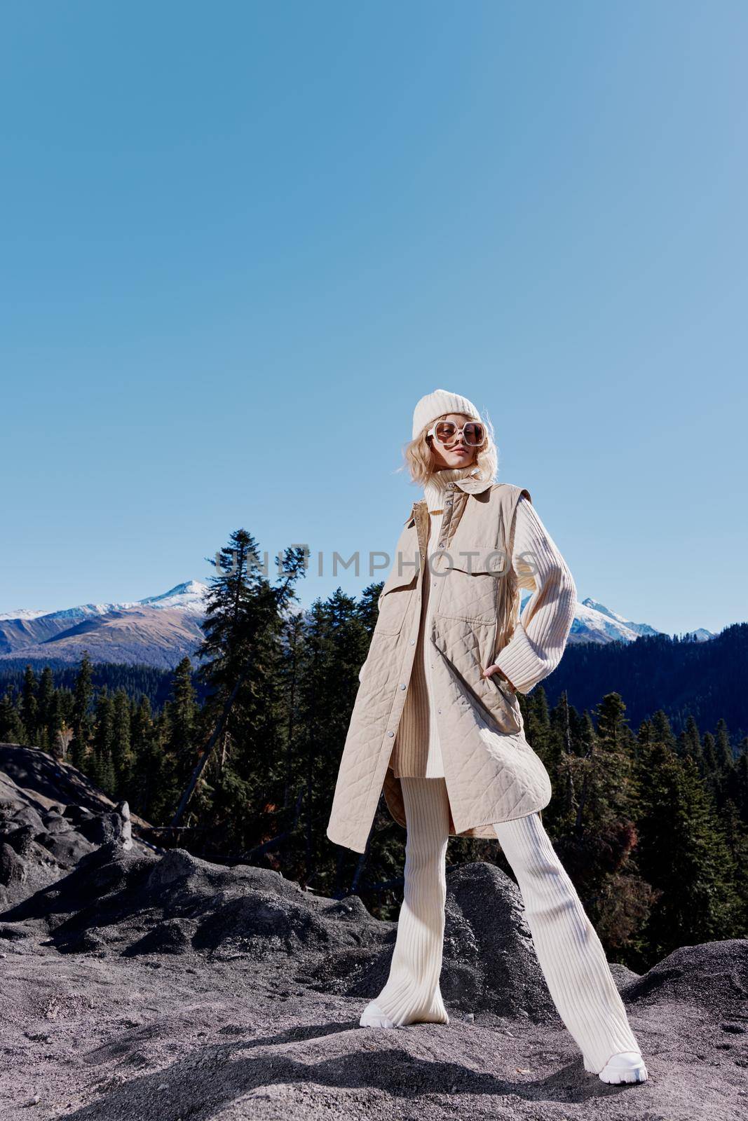 Stylish woman standing on the top of the mountain forest landscape. High quality photo