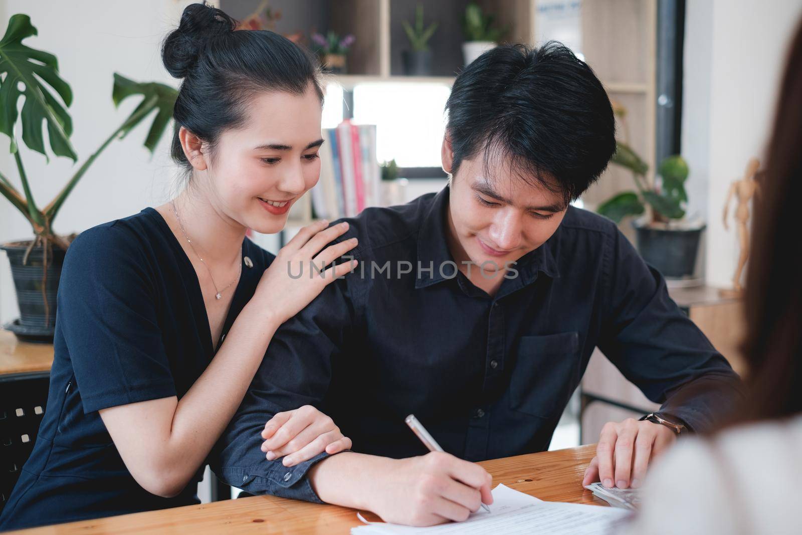 Business woman and young couple signing agreement for buying house. Bank manager and real estate concept