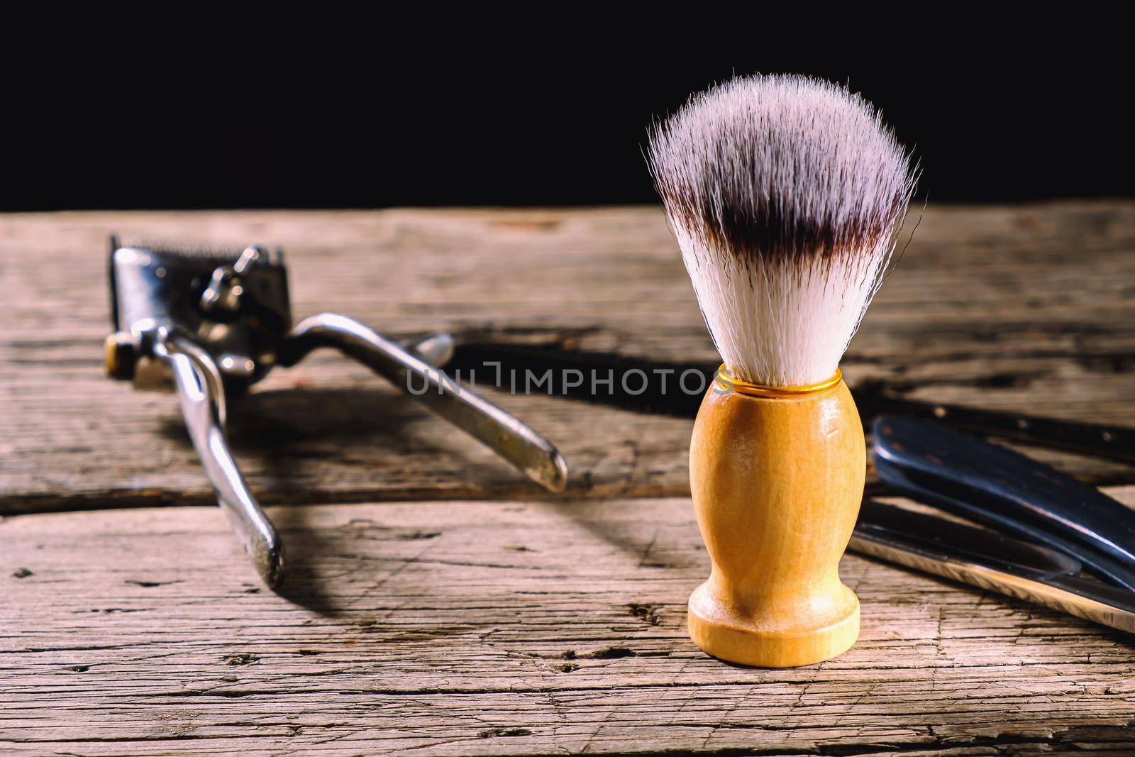 On a rustic wooden weathered surface are old barber tools. Vintage manual hair clipper comb razor shaving brush shaving brush hairdressing scissors. horizontal.