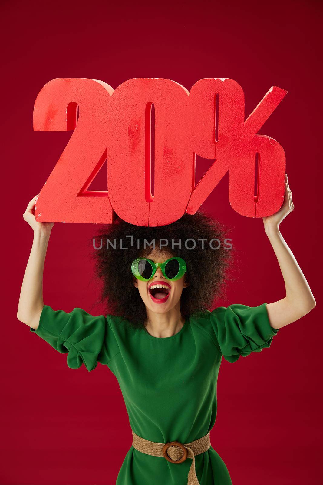 Positive young woman curly hairstyles green dress twenty percent discount color background unaltered by SHOTPRIME