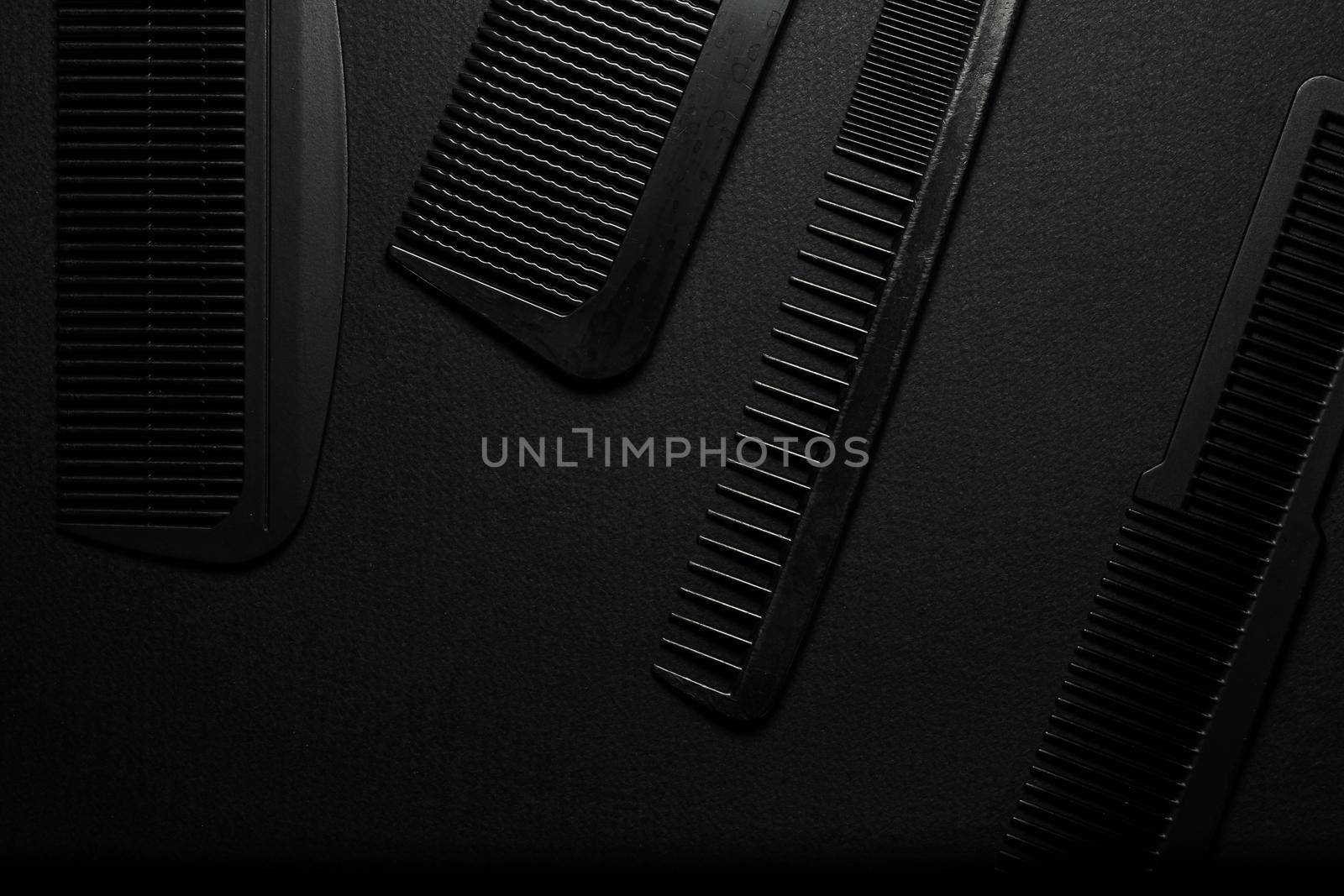 On a black surface are old barber tools. barber tools. four comb. black monochrome. frame. top view flate lay.