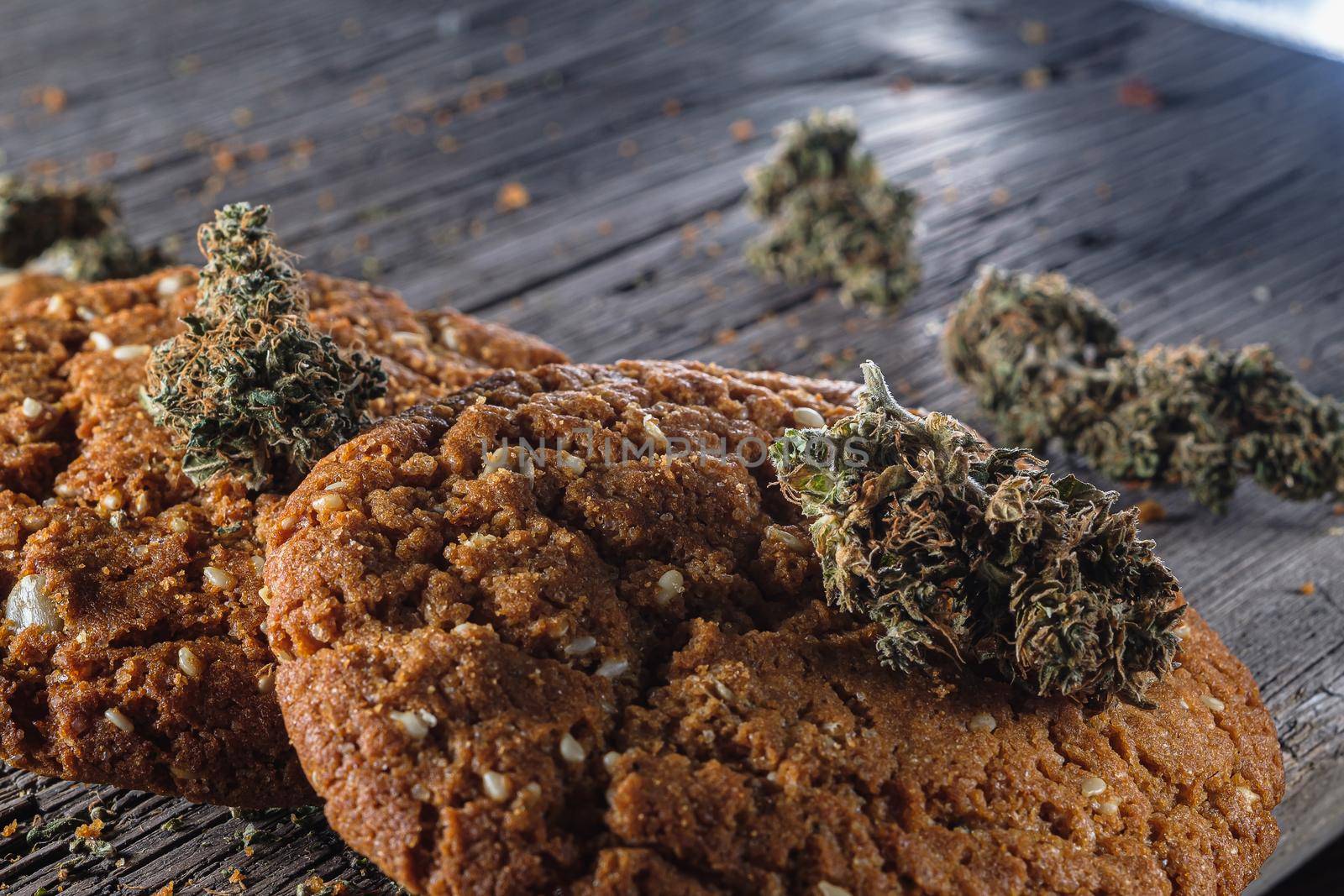 biscuits with marijuana on an old wooden background close-up. Healthy food with medical cannabis. the buds are inaccurately scattered. rustic. Horizontal orientation.