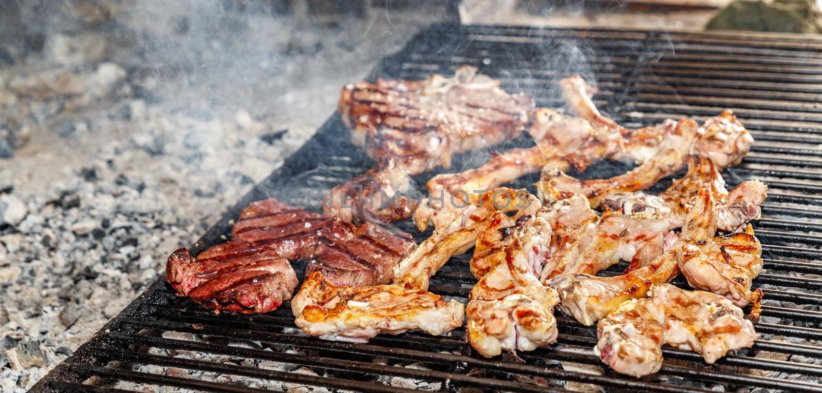 Lamb chops and sirloin steak on grill, shallow depth of field