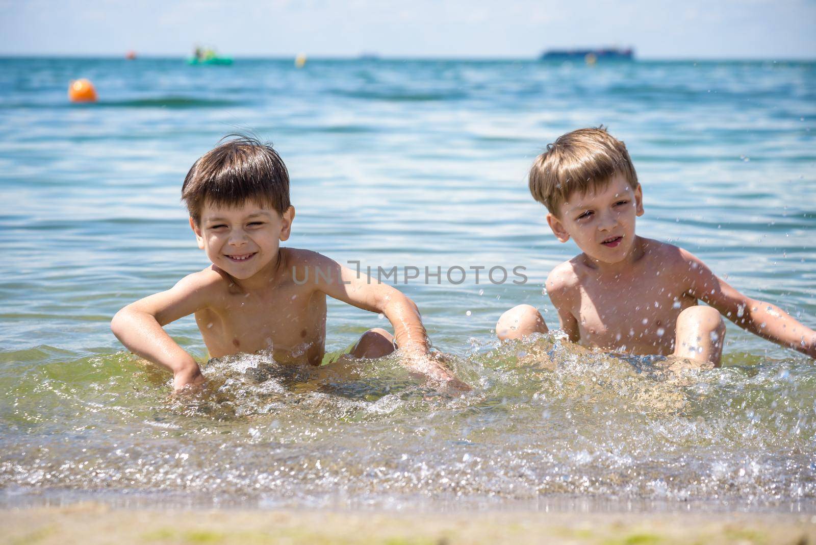 Happy family playing in blue water of swimming pool on a tropical resort at the sea. Summer vacations concept. Two brother kids are best friends by Kobysh