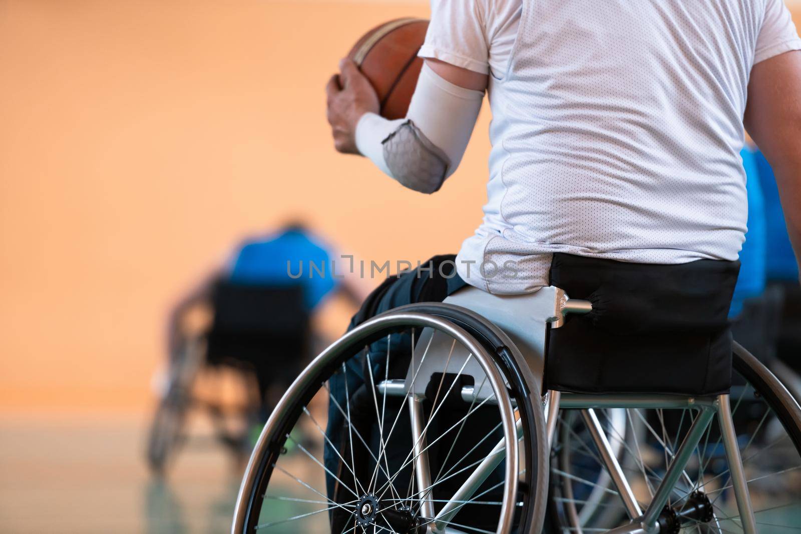 Close-up of sportsman with disability sitting in wheelchair playing basketball. High quality photo