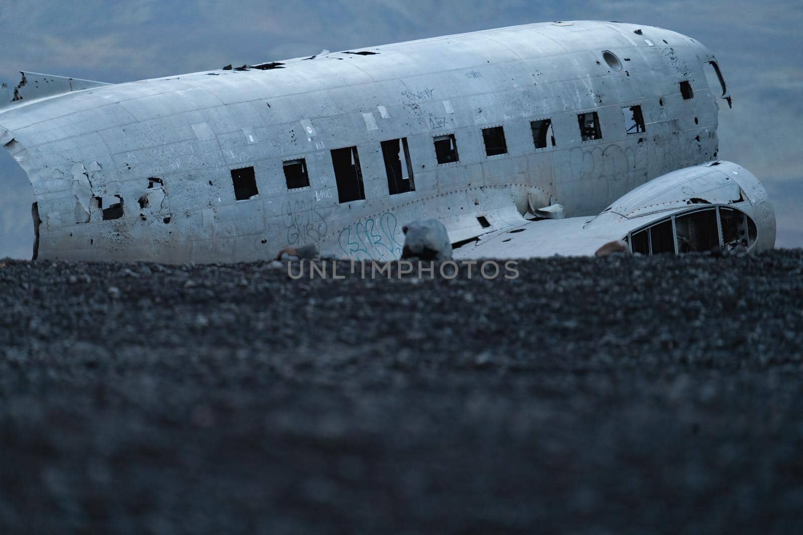 Wreck of and airplane profile over the dark black sand