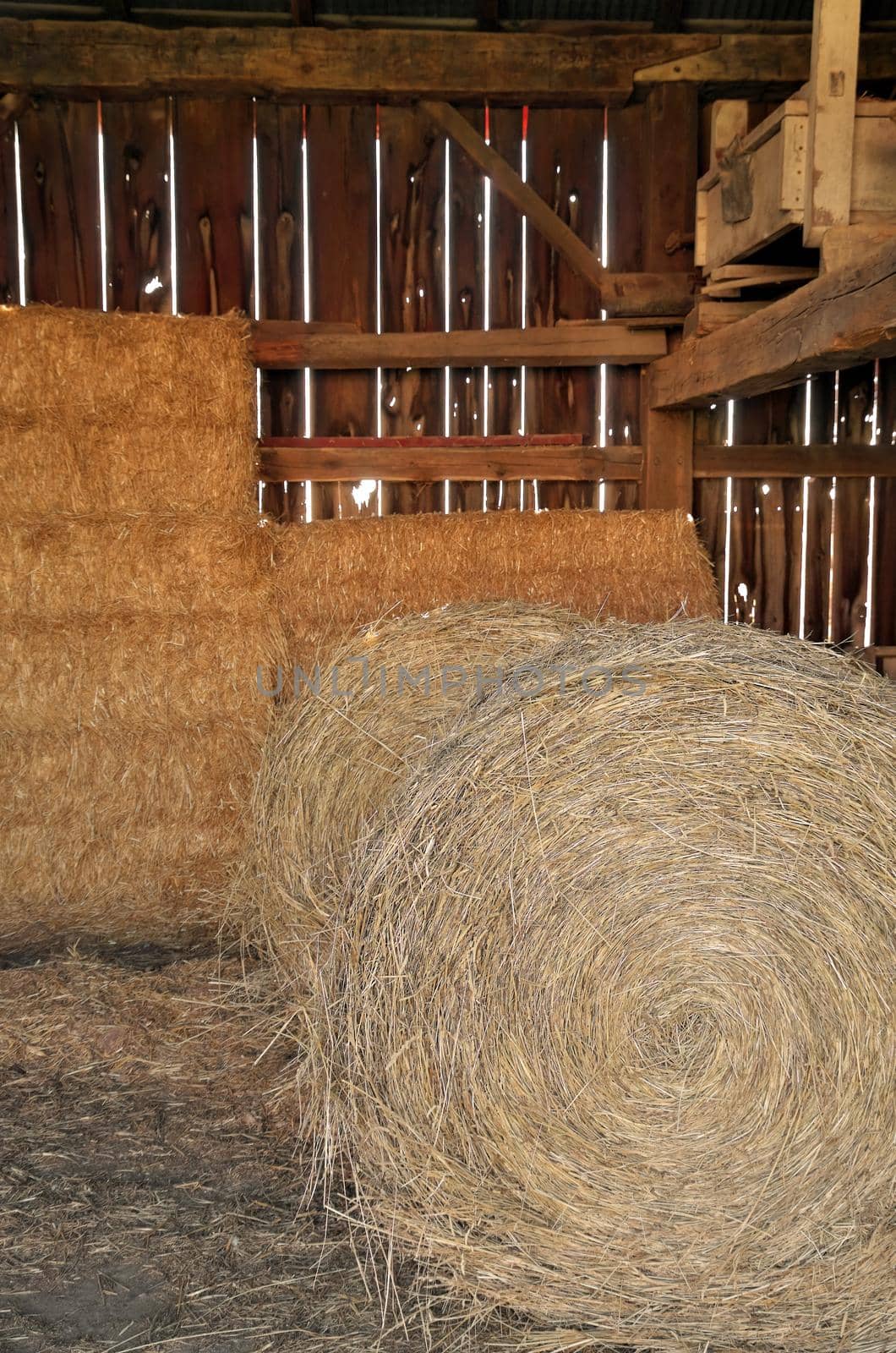 Close up of Round and Square Hay Bales in an old wooden Barn by markvandam