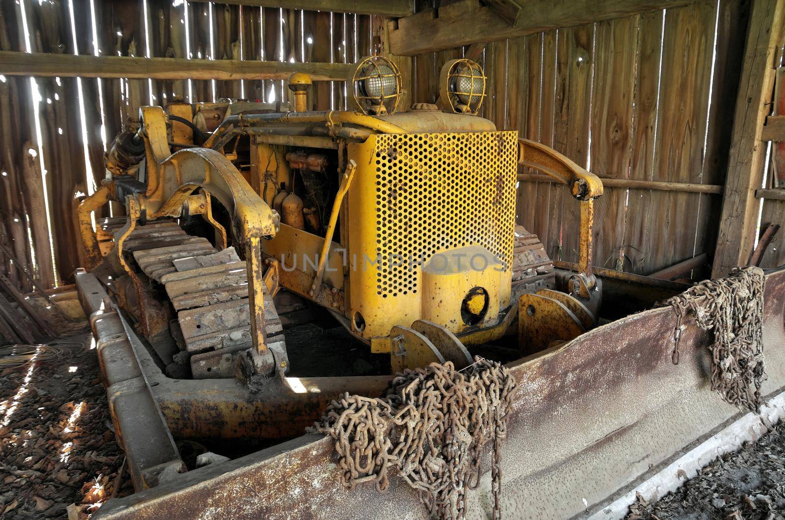 Yellow Antique Vintage Bulldozer Stored in an Old Rustic Barn. High quality photo