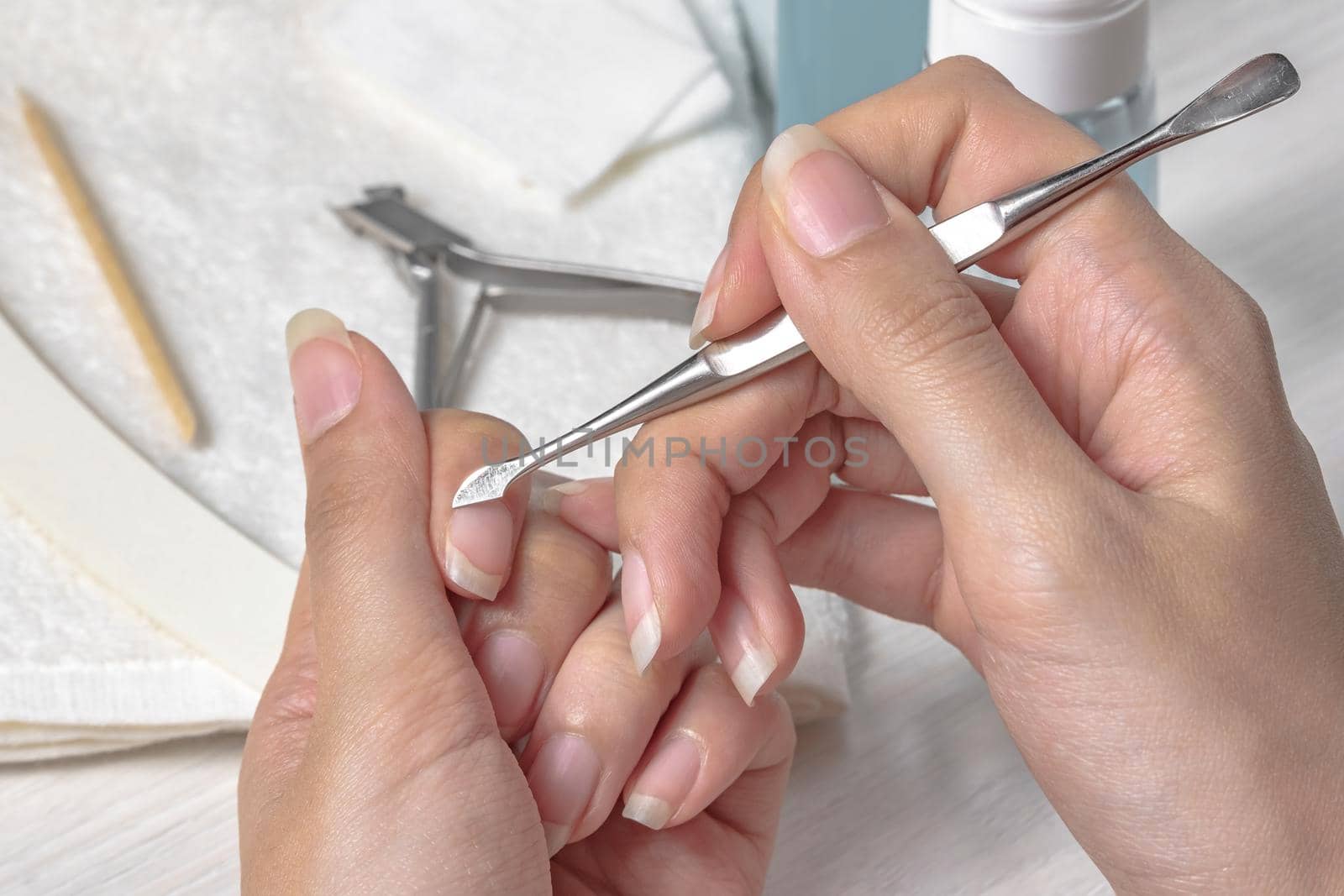 Manicure.Push back the cuticle with a metal pusher.Getting injured during manicure. Skin care,hands,nails,hygiene.Spa salon, nail salon.Home care. Beauty.Women's hands