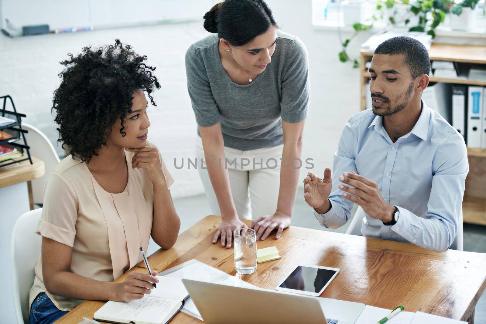 Shot of a group of professionals using wireless technology during a meeting