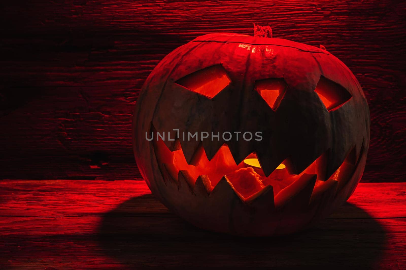 Jack O' Lantern Glowing In Fantasy Night. Halloween. On old wooden background. dramatic frame. horizontal orientation