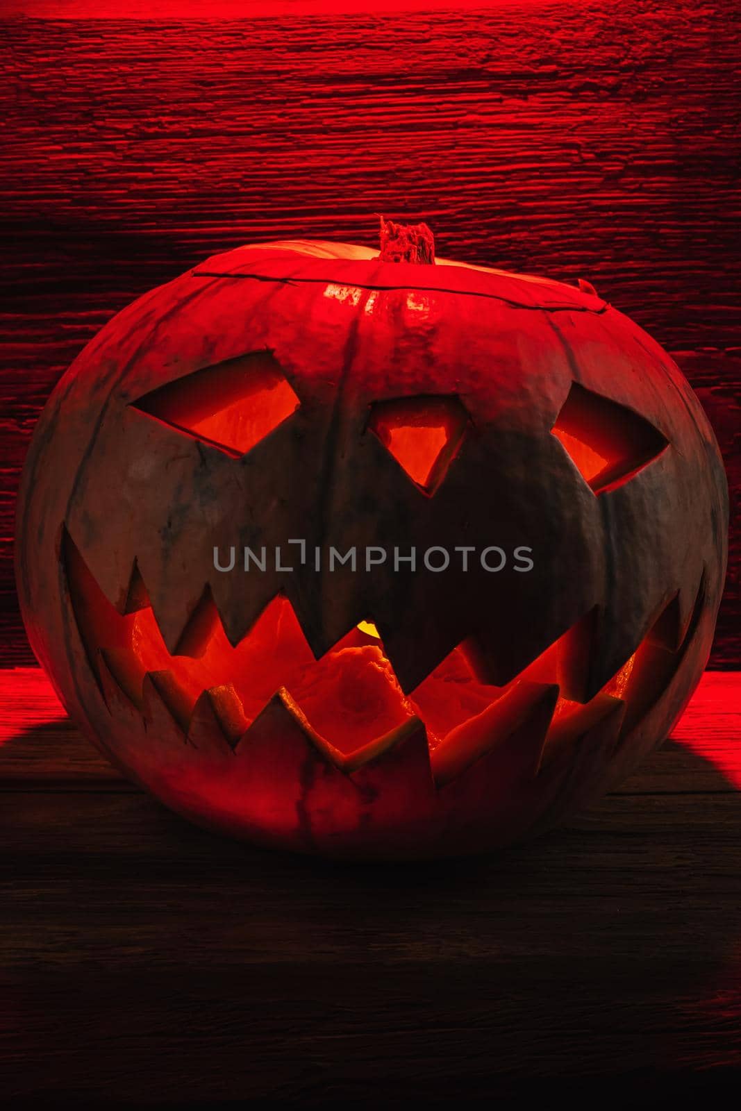 Jack O' Lantern Glowing In Fantasy Night. Halloween. On old wooden background. dramatic frame. vertical orientation/