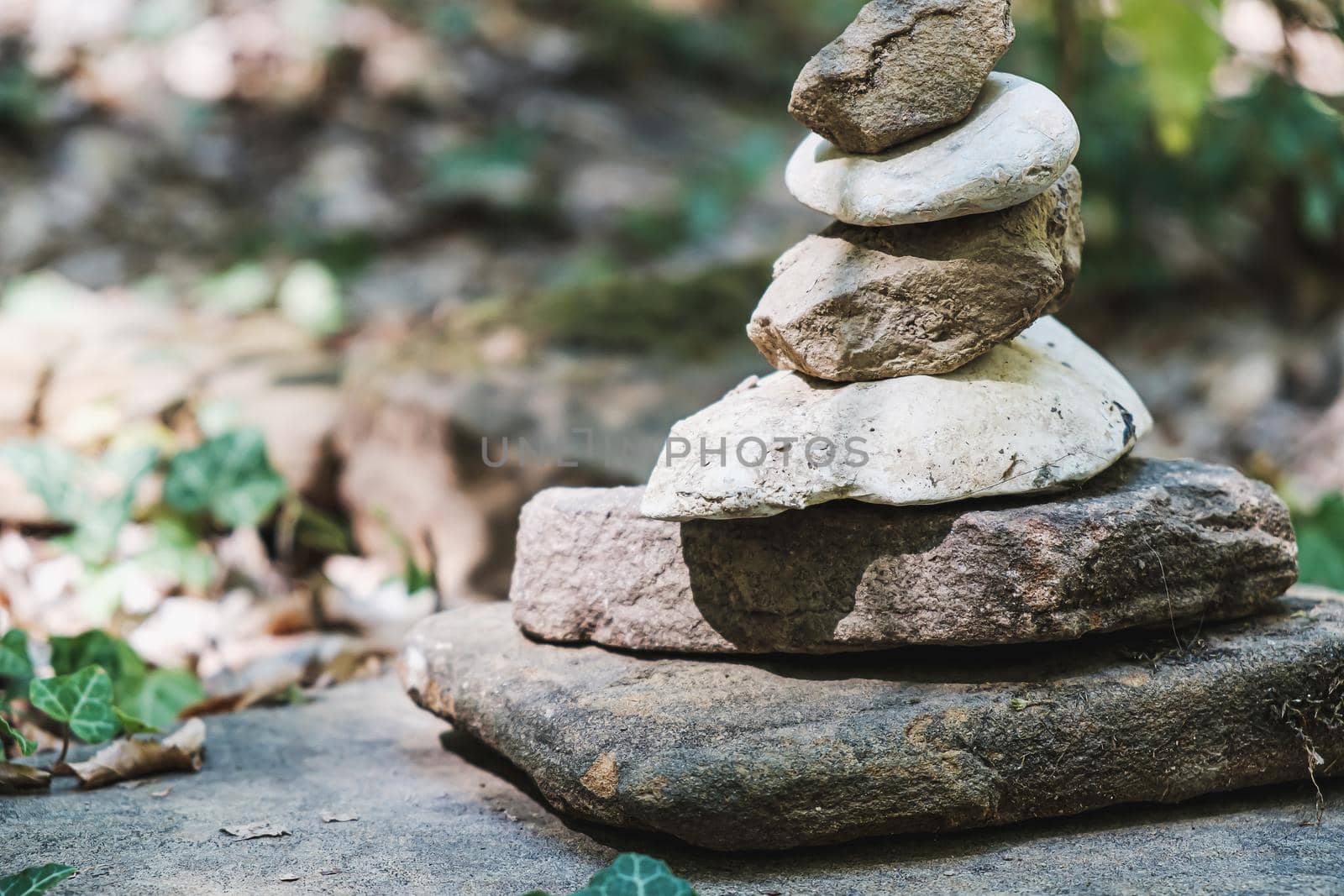 zen stone stack with balanced stones on stones in equilibrium, pile of rocks in the woods by Alexander_V