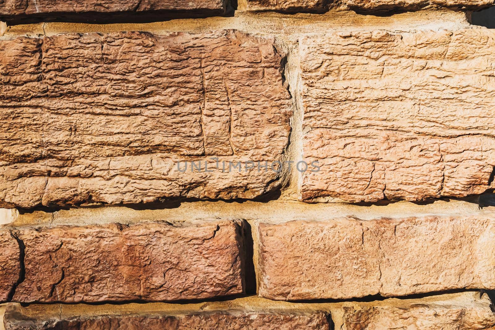 stylized old brickwork geometric pattern uneven textured beautiful warm stone surface. decor. close-up. brown background. flat lay.