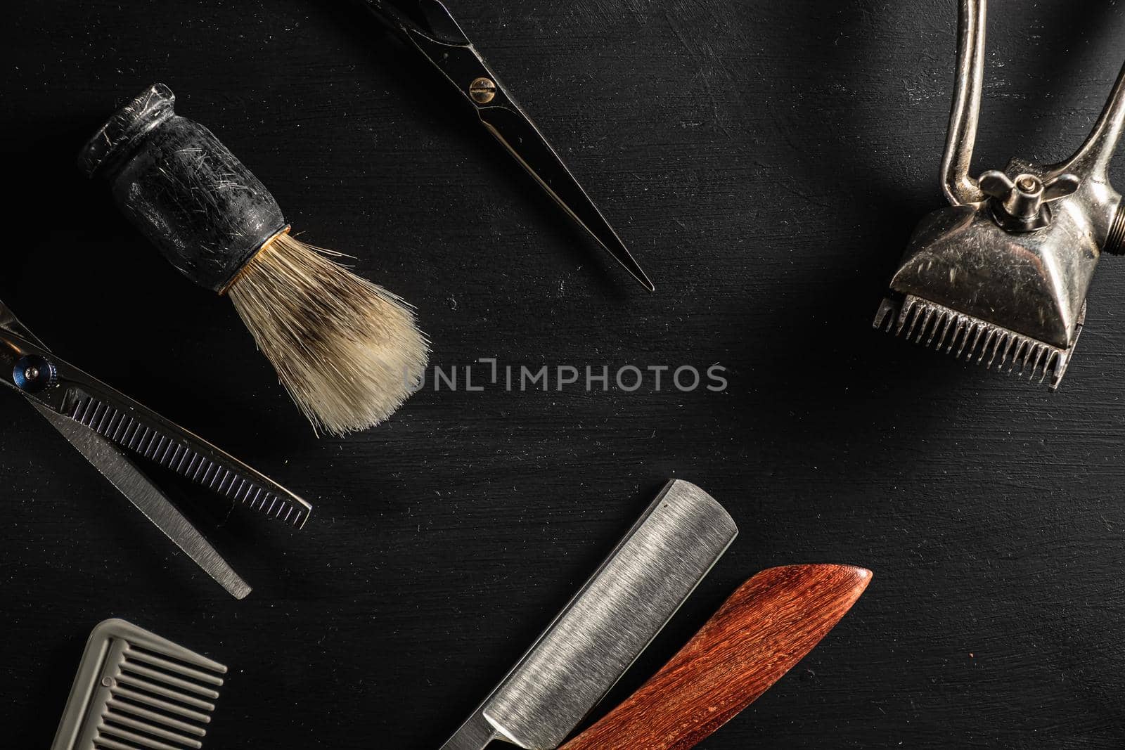 barber tools. hairdressing scissors vintage manual clipper comb brush dangerous razor are on a on a black dusty surface. copy space. Horizontal orientation. Close-up. flat lay. top view