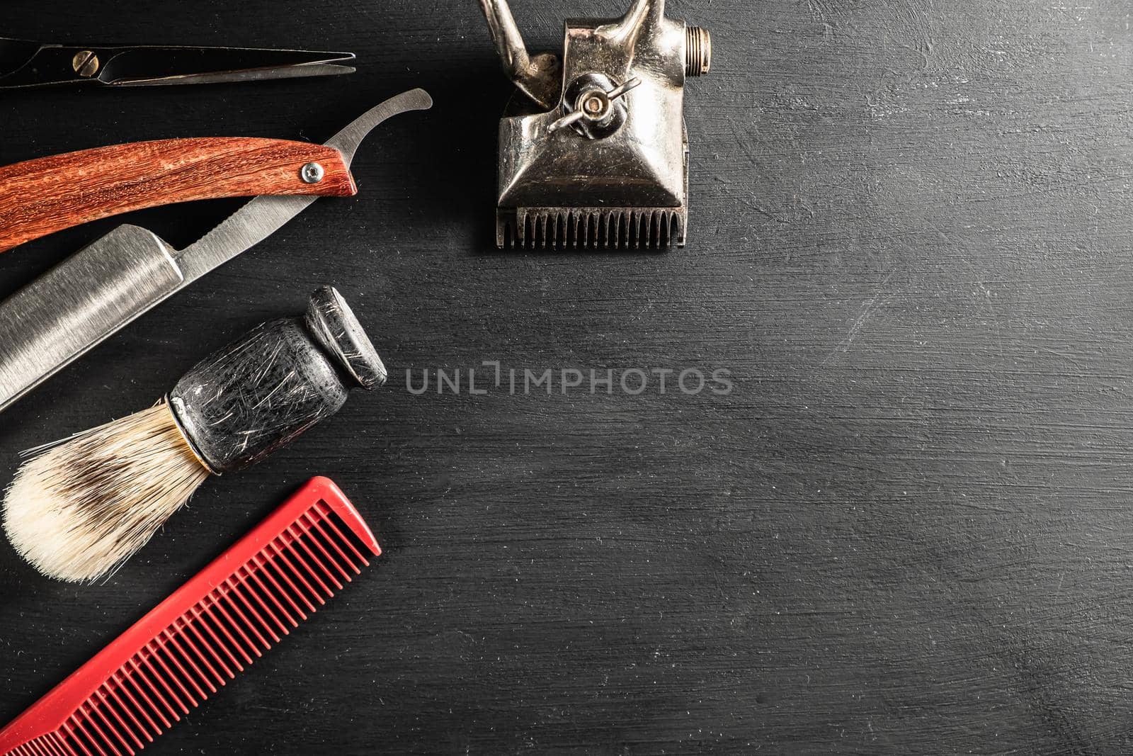 barber tools. hairdressing scissors vintage manual clipper comb brush dangerous razor are on a on a black dusty surface. copy space. Horizontal orientation. Close-up. flat lay. top view