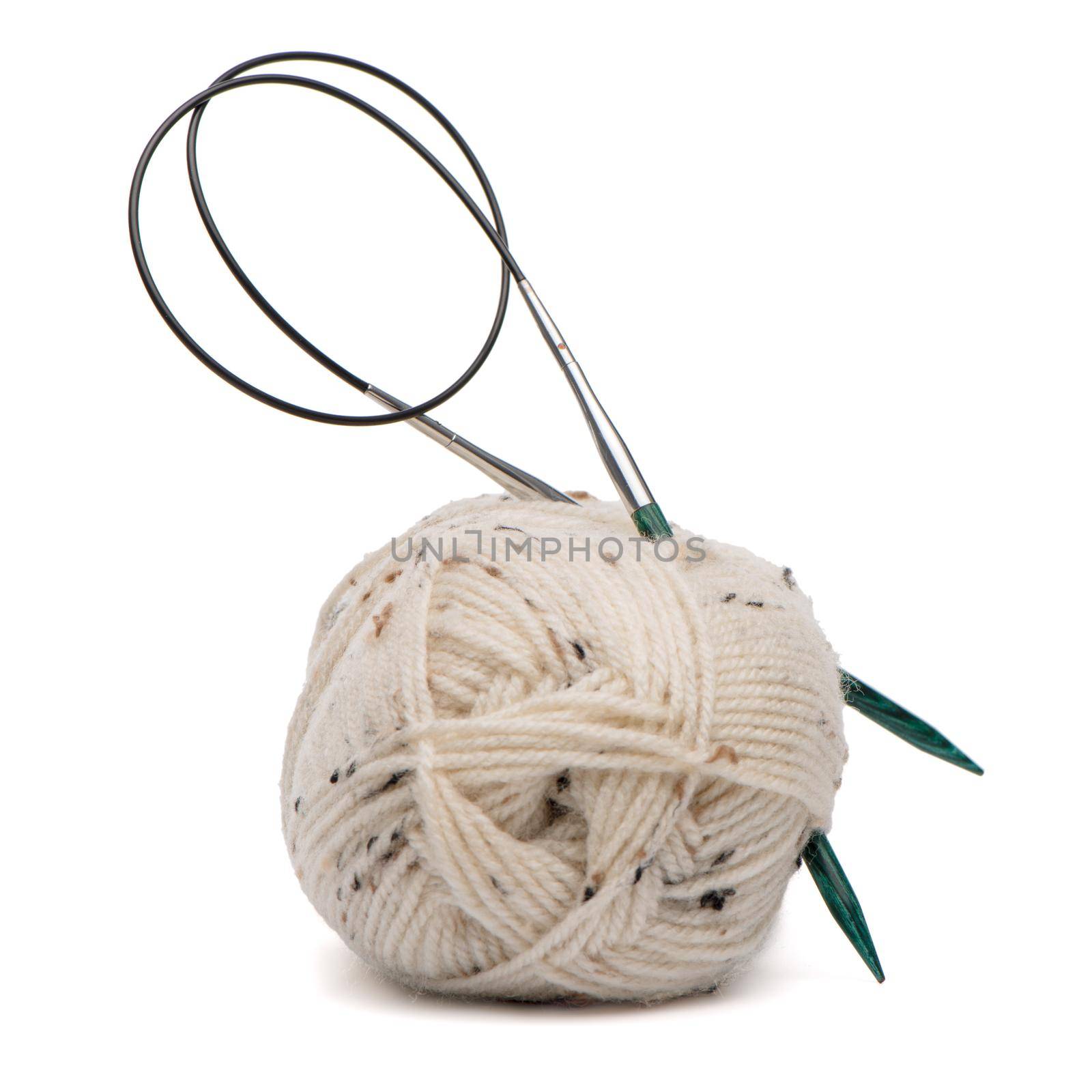 Beige knitting wool or yarn with knitting needles.