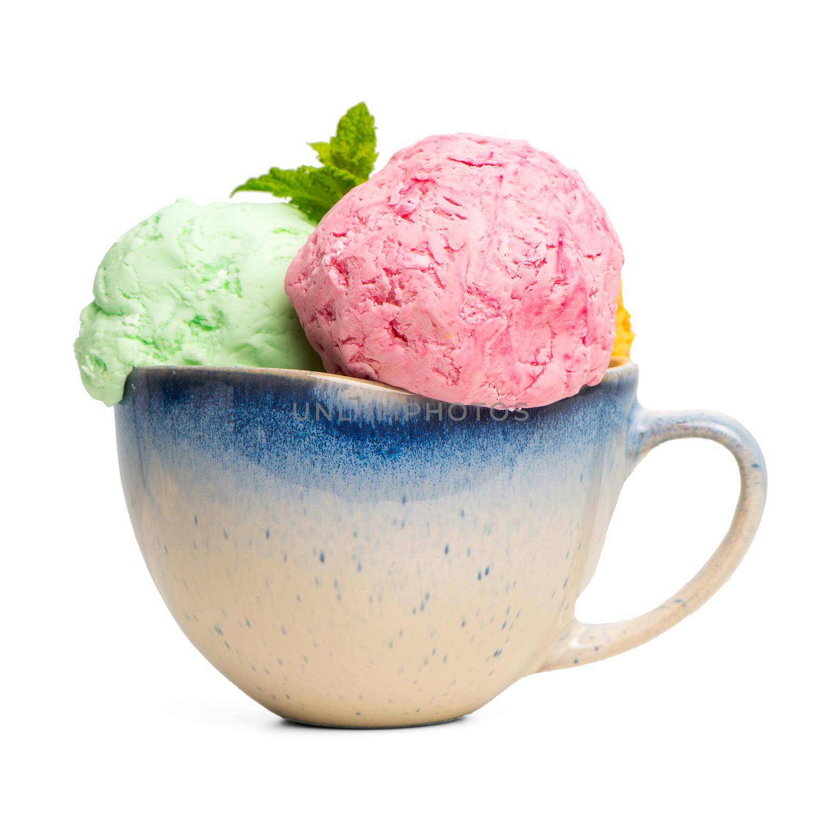 Ceramic bowl of various colorful ice cream balls with mint leaves  isolated on white background. From side view.