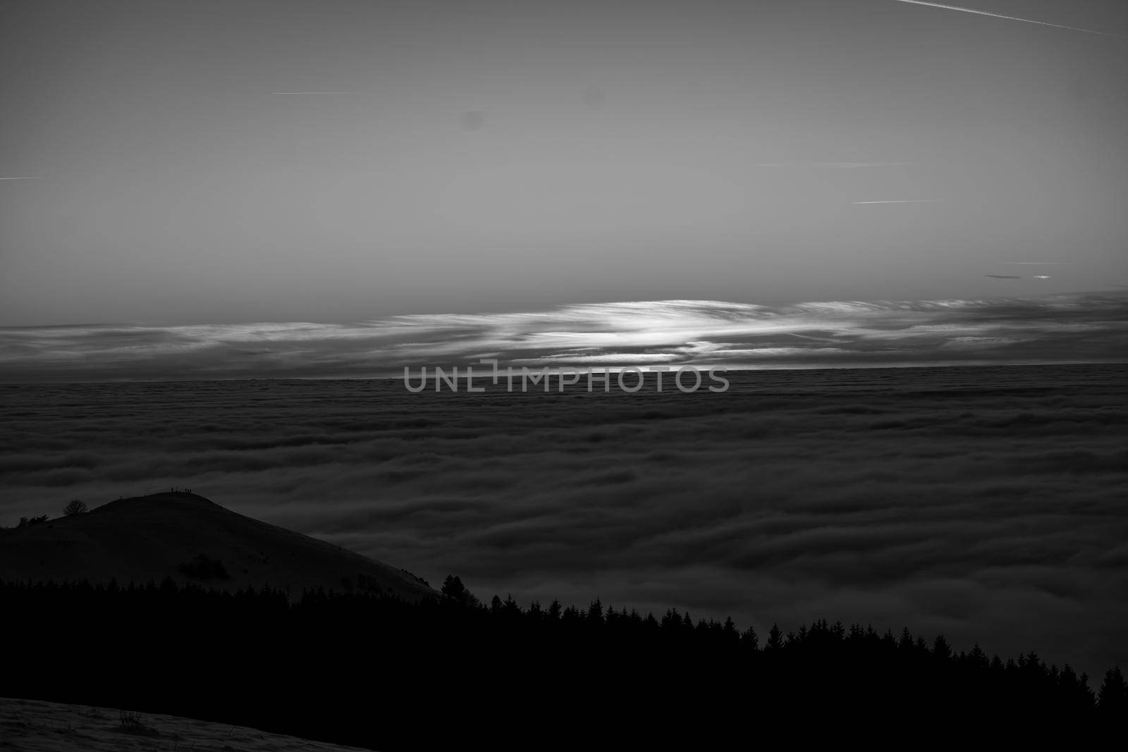 the romance of tourism and recreation, as well as the principles of a healthy lifestyle, is to watch the fantastic play of the sun's rays setting over the horizon on the highest Wasserkuppe mountain in Hesse, Germany and breathe fresh clean mountain air black and white photo by Costin