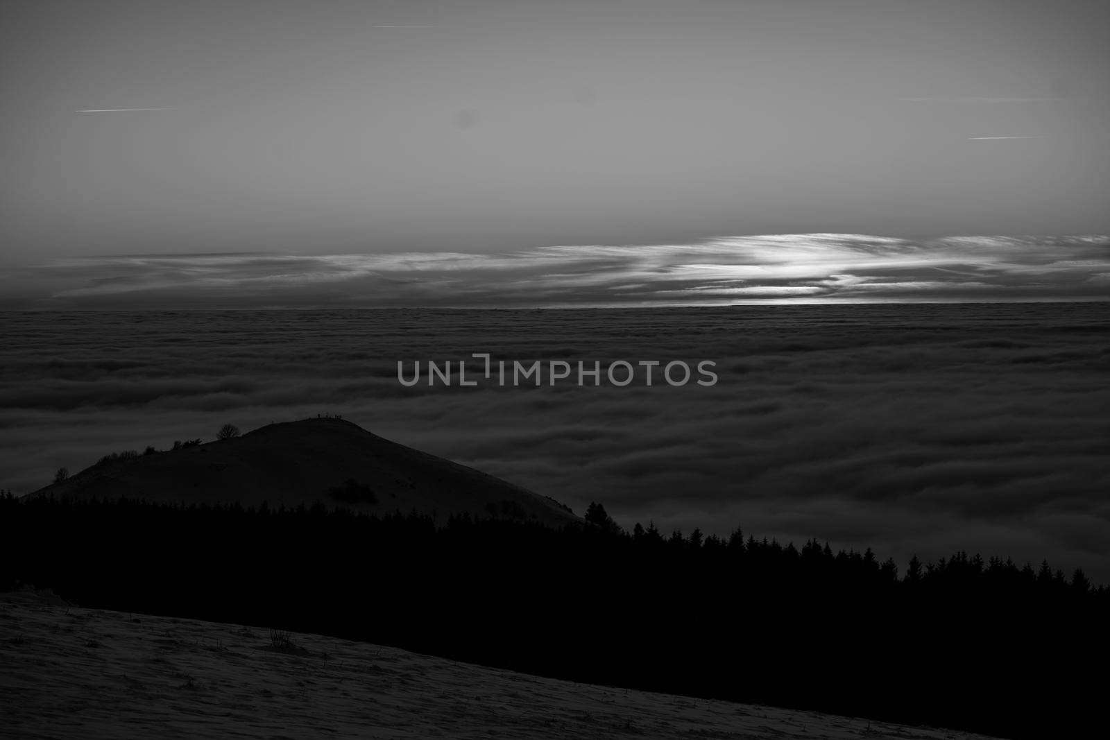 the romance of tourism and recreation, as well as the principles of a healthy lifestyle, is to watch the fantastic play of the sun's rays setting over the horizon on the highest Wasserkuppe mountain in Hesse, Germany and breathe fresh clean mountain air black and white photo by Costin