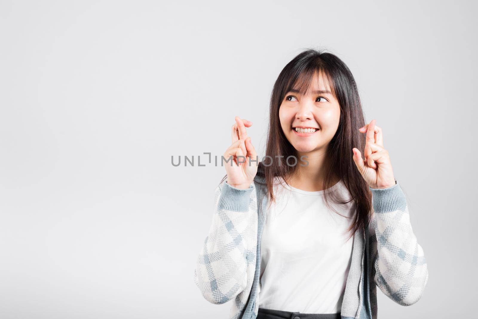 Happy woman have superstition her holding fingers crossed for good luck gesture, Asian beautiful young female smiling superstition, studio shot isolated on white background with copy space