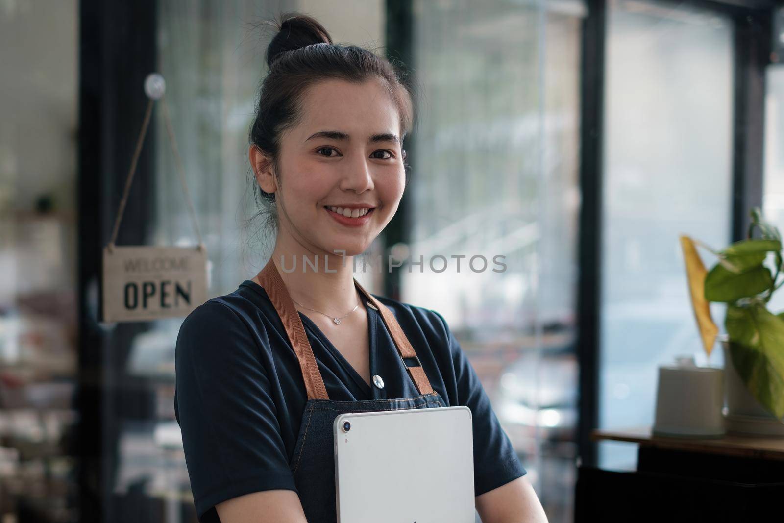 Portrait of asian woman barista cafe owner smile while cafe open. SME entrepreneur seller business concept