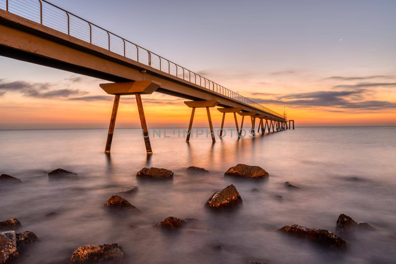The sea pier of Badalona before sunrise by elxeneize