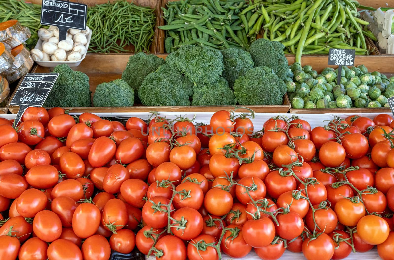 Tomatoes, broccoli and green peas for sale at a market