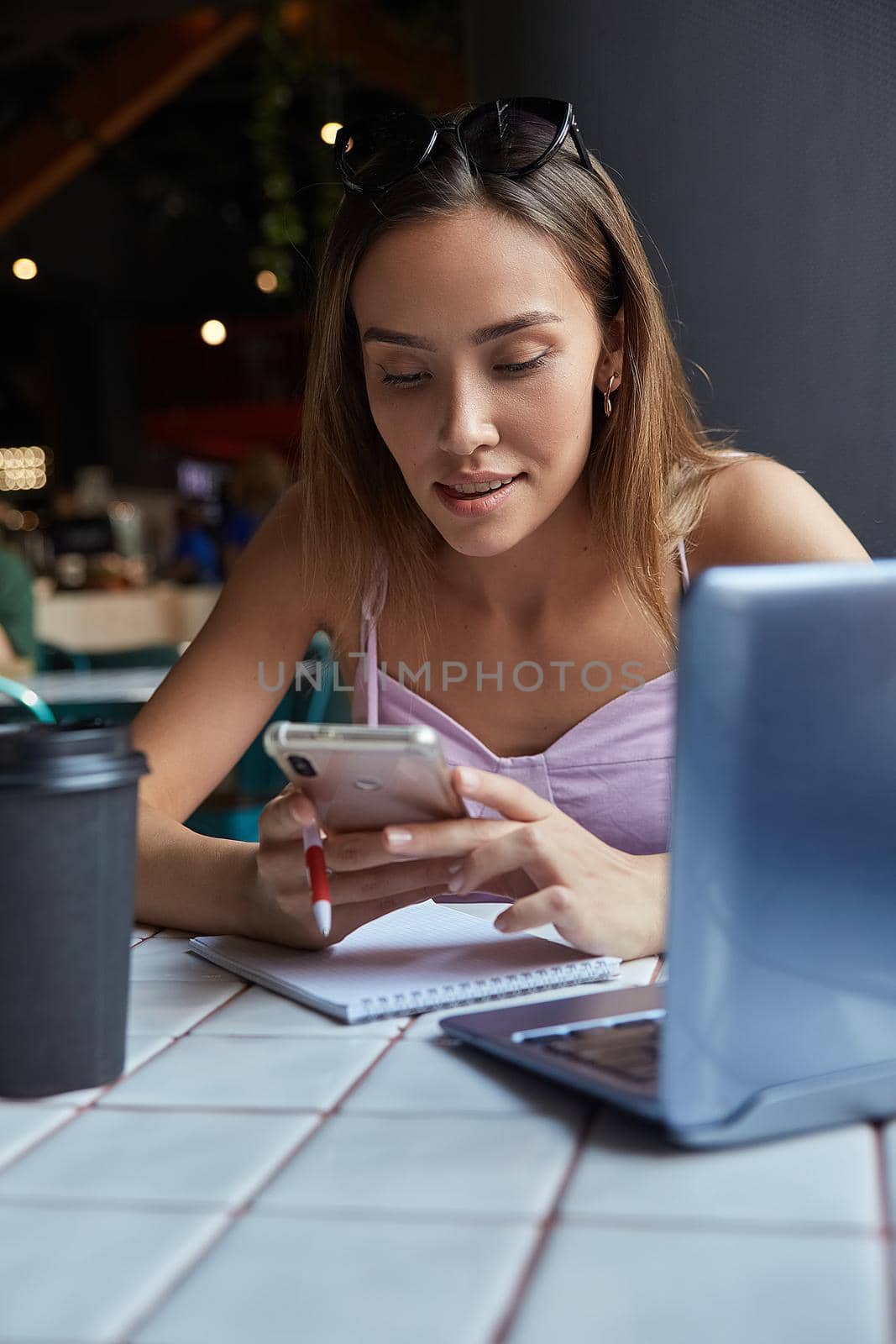 young well dressed asian woman sitting at table, using her smartphone. beautiful lady surfing internet on cell phone at cafe, chatting online. modern communication technology, distant work, remote job