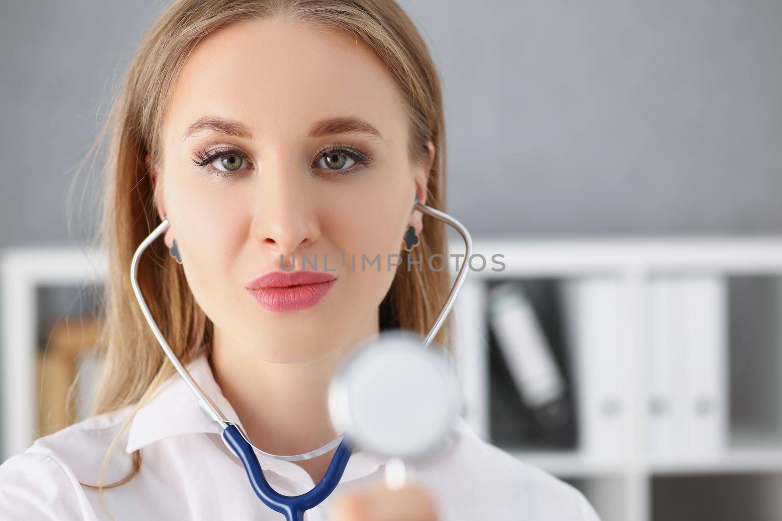 Portrait of a beautiful female doctor with a stethoscope. Stylish medical officer, close-up of a woman's face