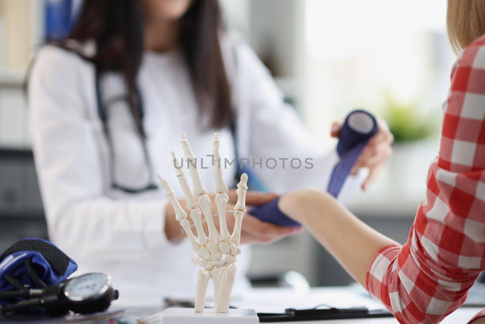 The doctor makes a bandage on the woman's wrist, close-up, blurry. bandage, arm sprain, osteoporosis, arthritis