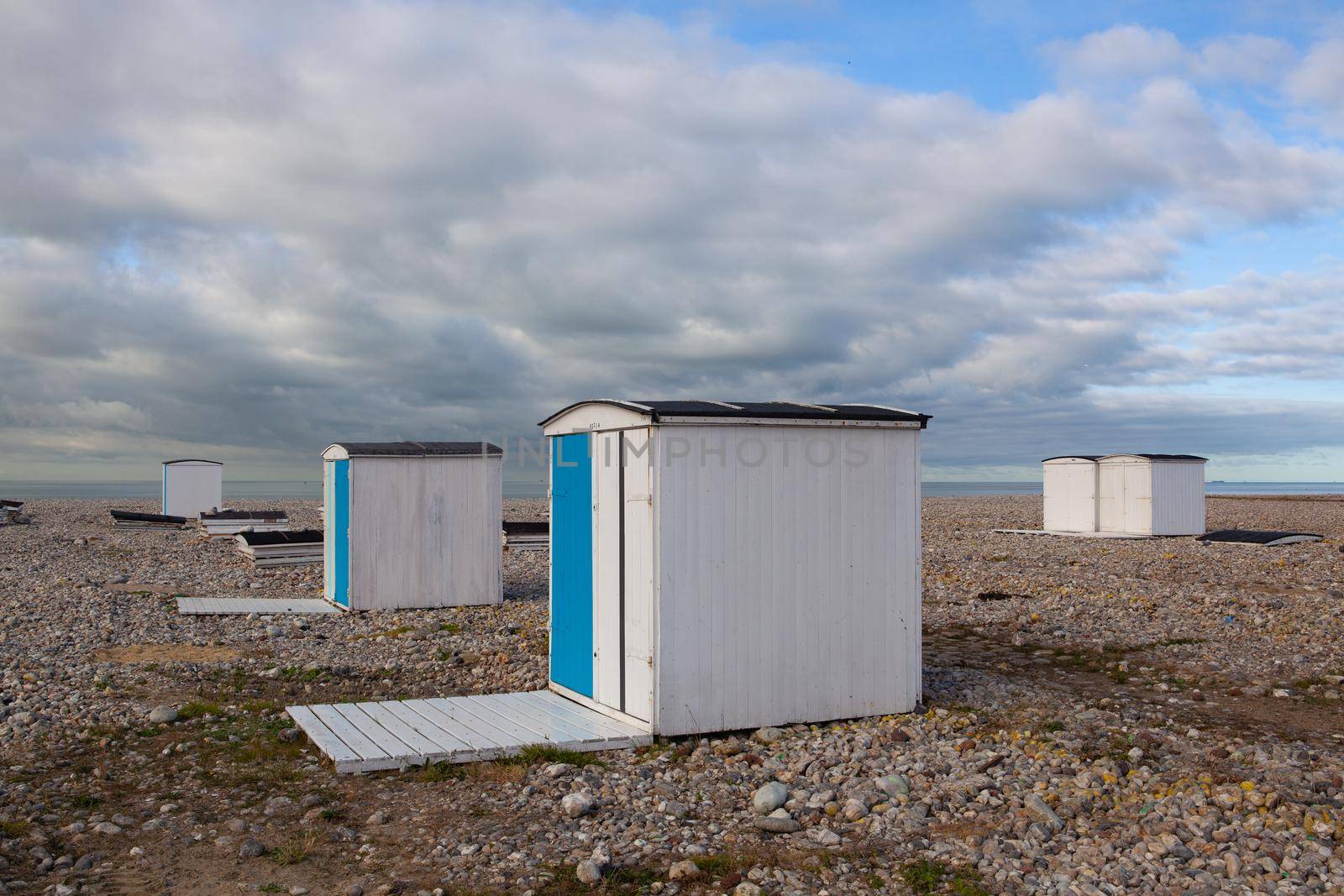 End of season on the beach, Le Havre, France. Small houses or beach cabins of different colors on the beach of Le Havre in France