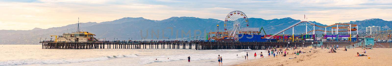 Santa Monica, United States of America - October 24, 2016: panorama of Pacific Park with pier, Ferris wheel, beach, ocean and mountains at sunset.