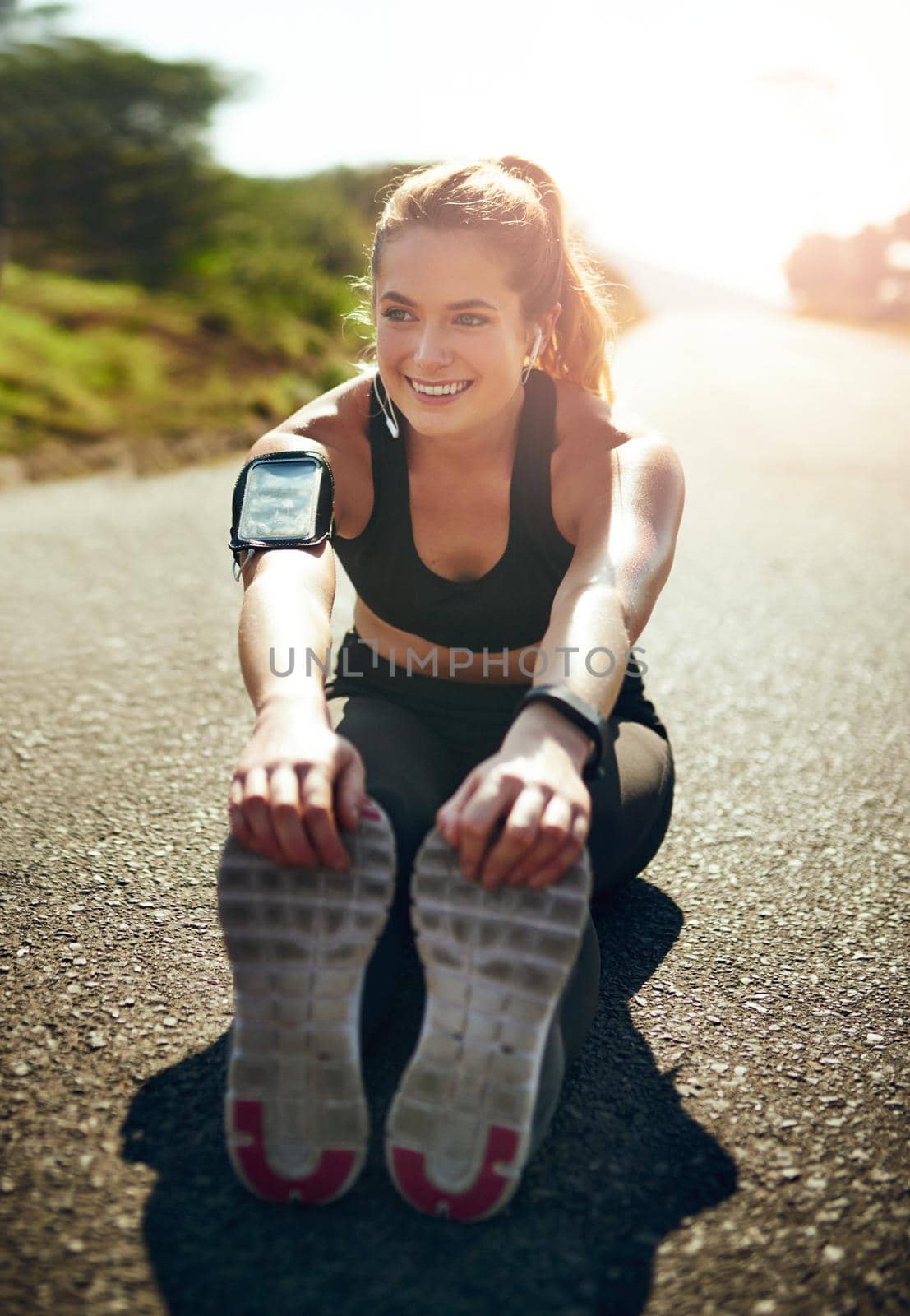 Shot of a young woman stretching before her run outdoors