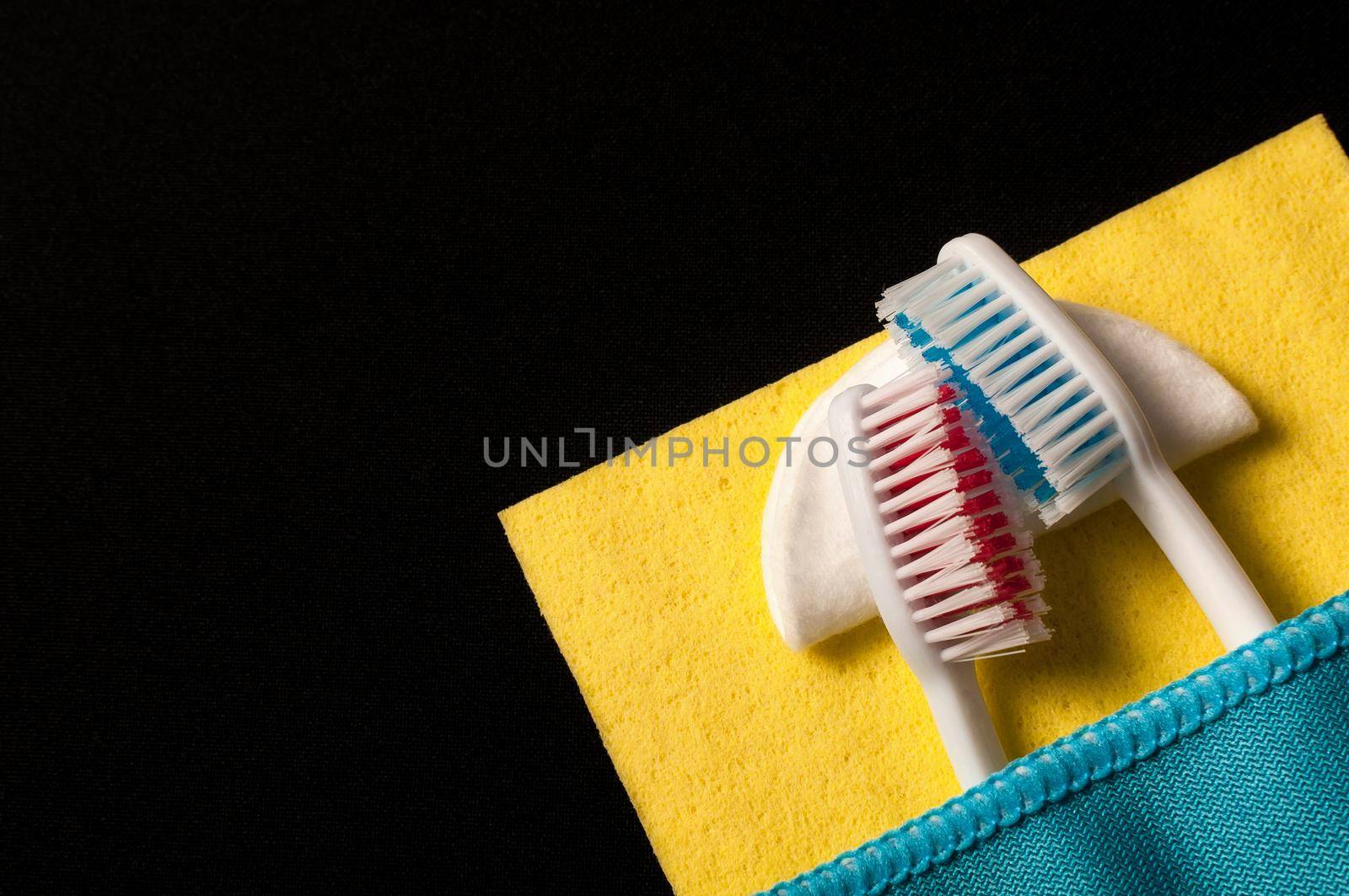 Toothbrushes under a blanket, on a black background by Evgenii_Leontev