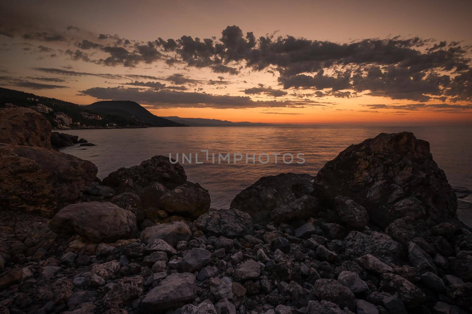 Marine landscape against the dawn. Mountains and clouds in the background