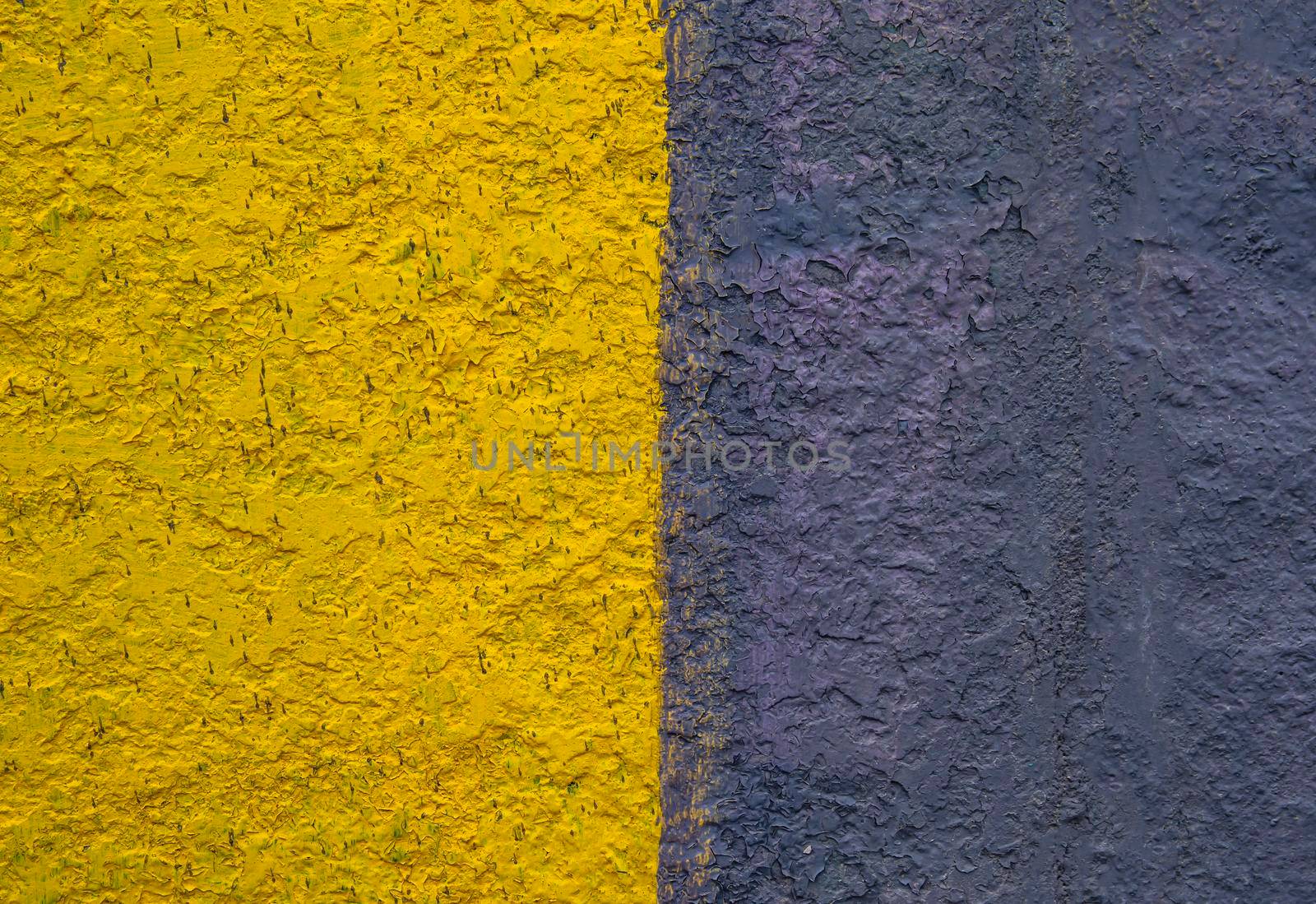 The surface is painted in half in yellow and black. Paint on a concrete wall. Texture of a colored surface. Black and yellow color. background image. Template for text. Two vertical halves.