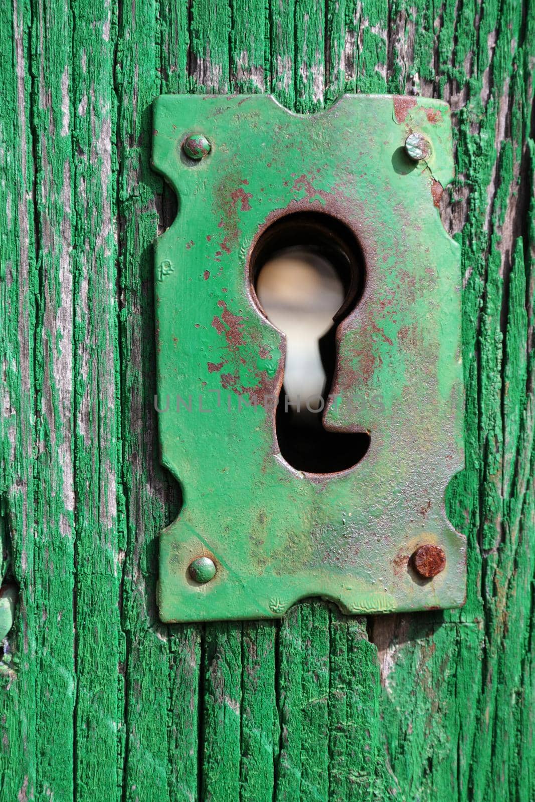 An old wood door with metal lock and keyhole
