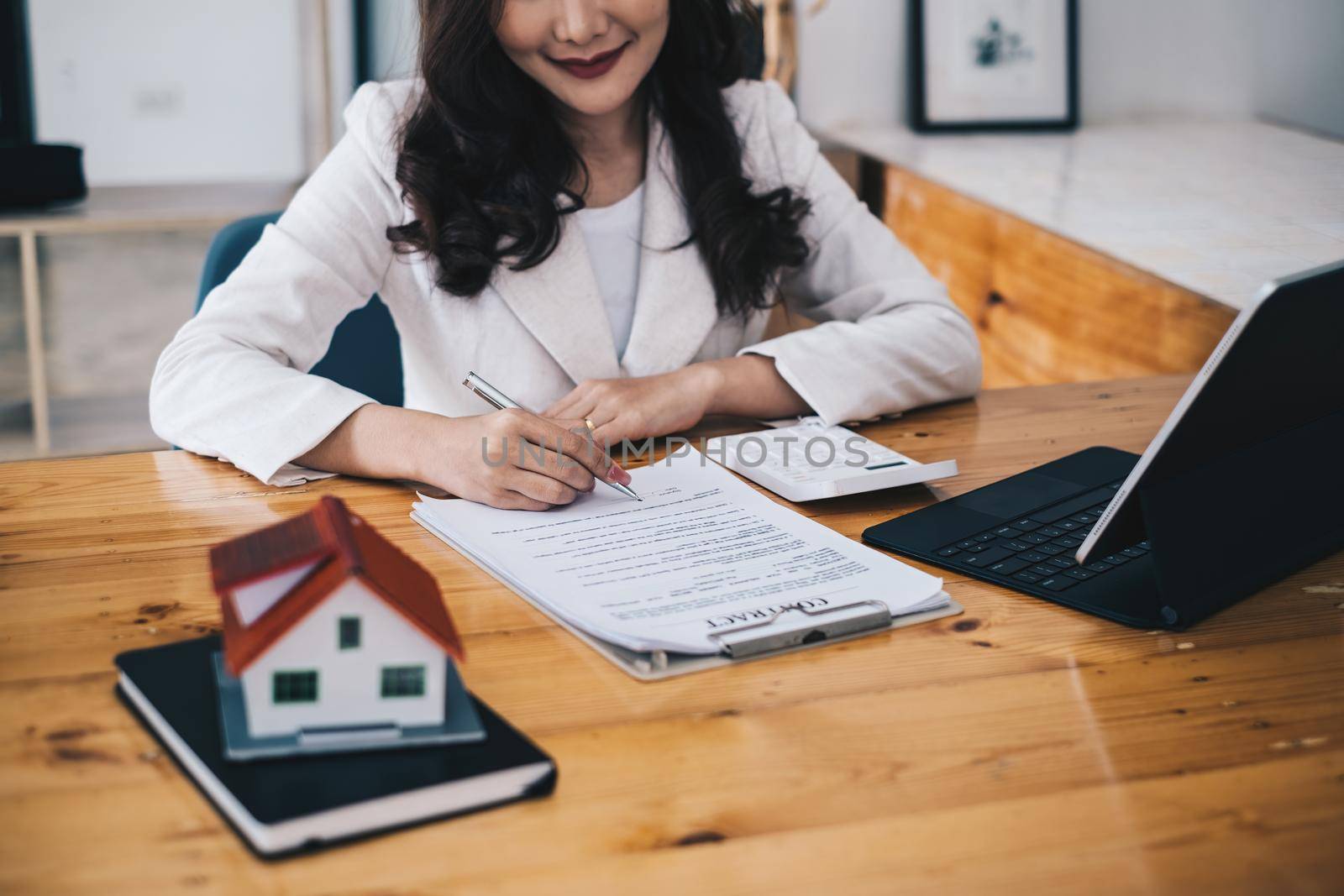 Business woman or broker checking contract agreement paper with customer to sign contract. Real Estate and Agreement concept. by itchaznong