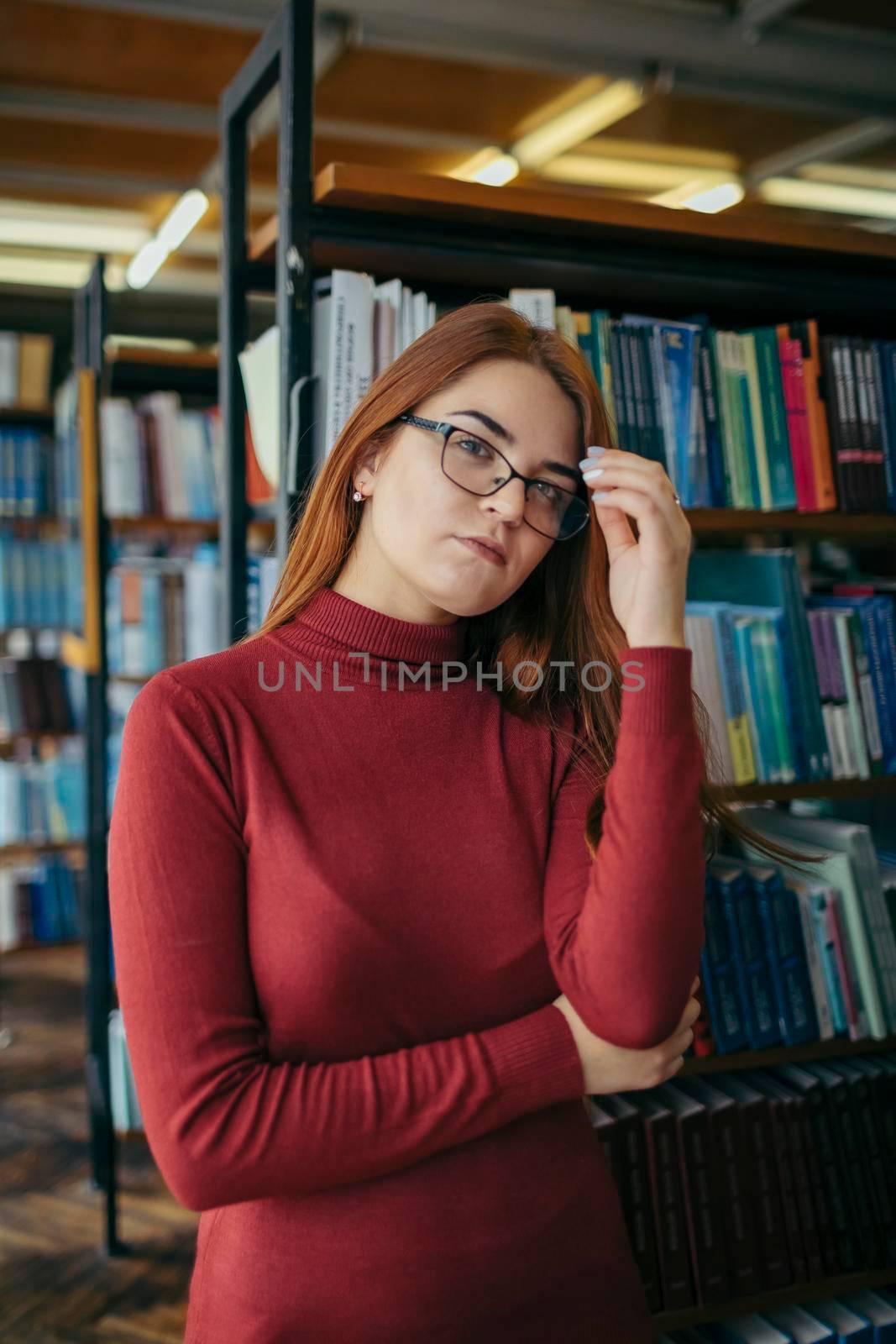 A woman standing in front of a book shelf. High quality photo