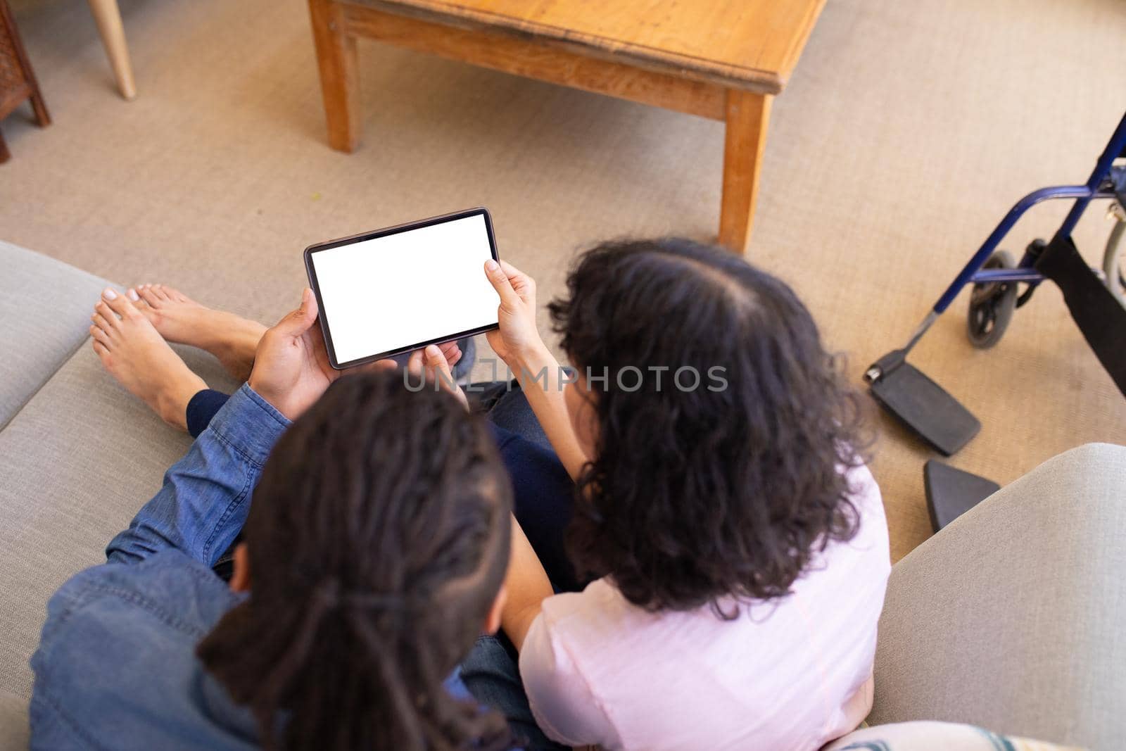 High angle view of young biracial couple using tablet pc with copy space on blank screen at home by Wavebreakmedia