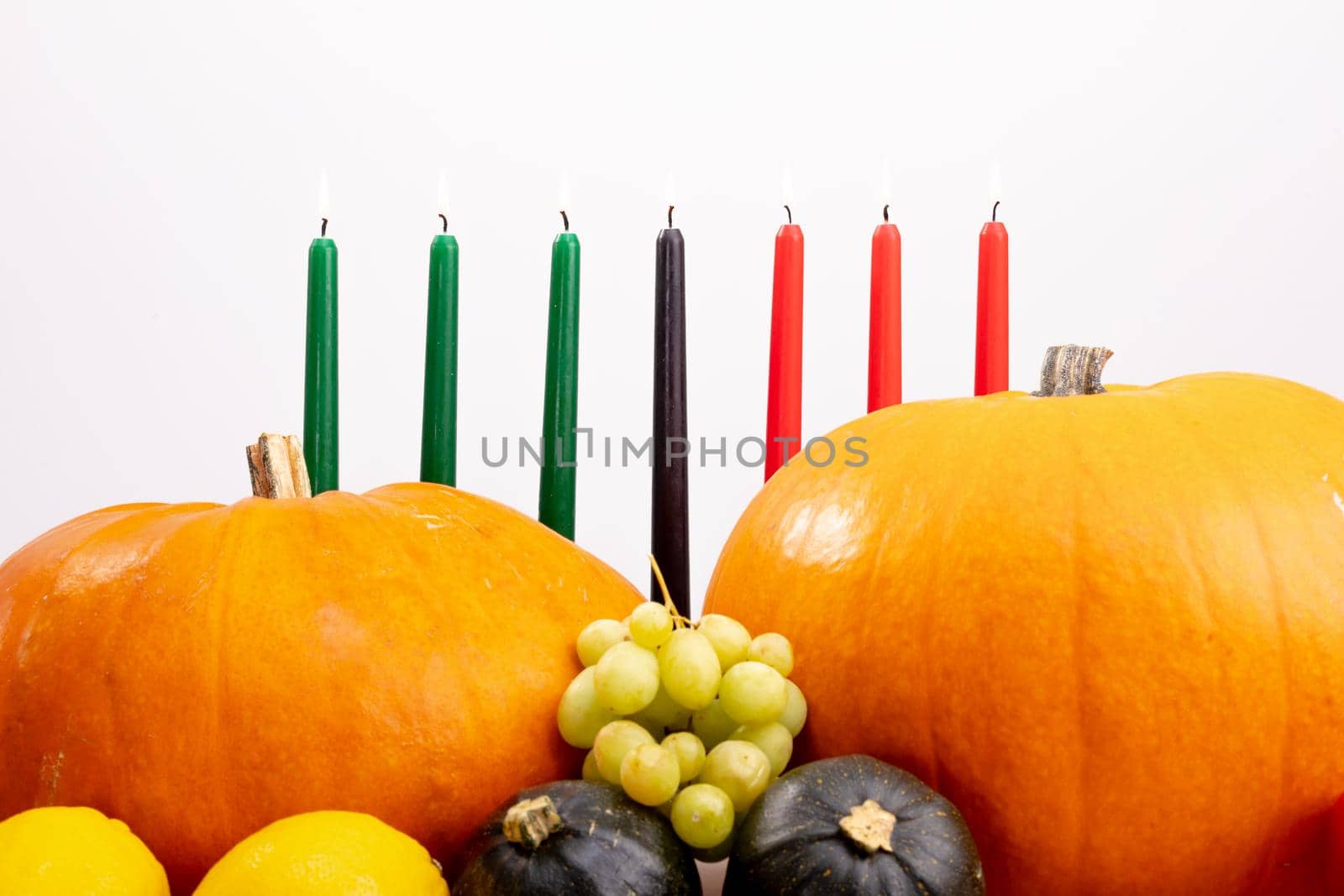 Composition of halloween decoration with pumpkins, fruits, candles, copy space on white background. horror, fright, halloween tradition and celebration concept digitally generated image.